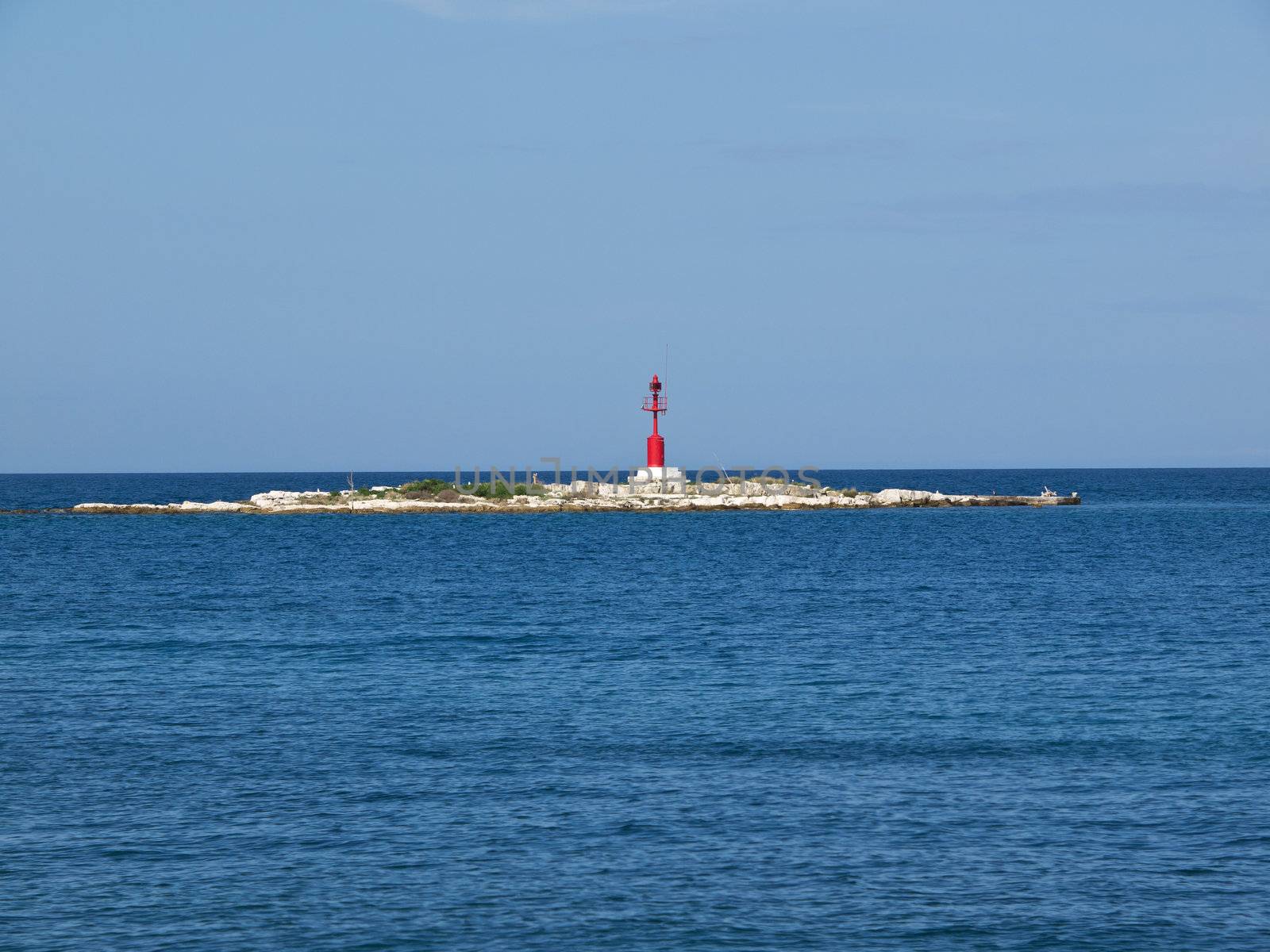 red lighthouse on a small island