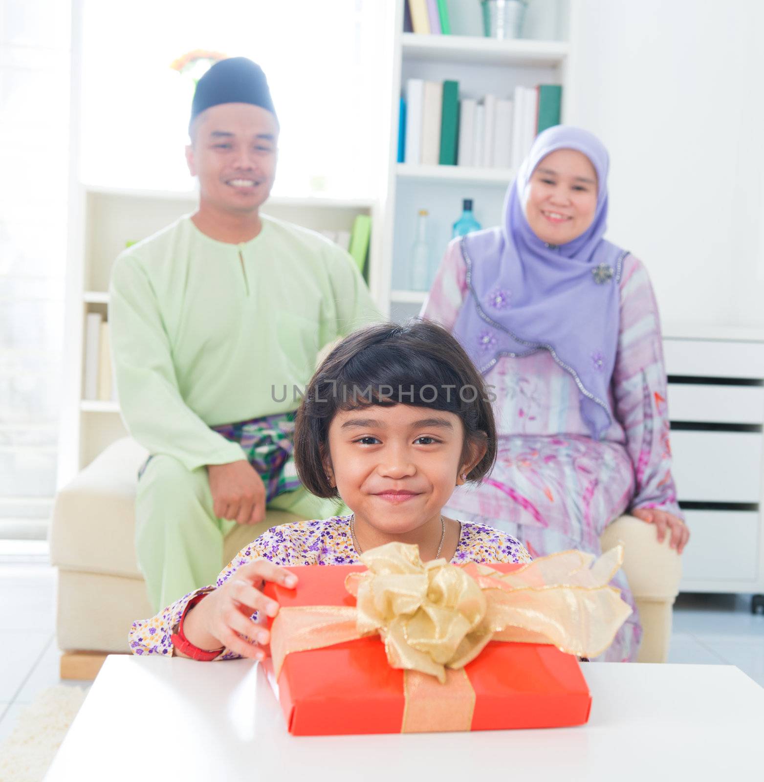 Southeast Asian girl with birthday present. Muslim family living lifestyle.