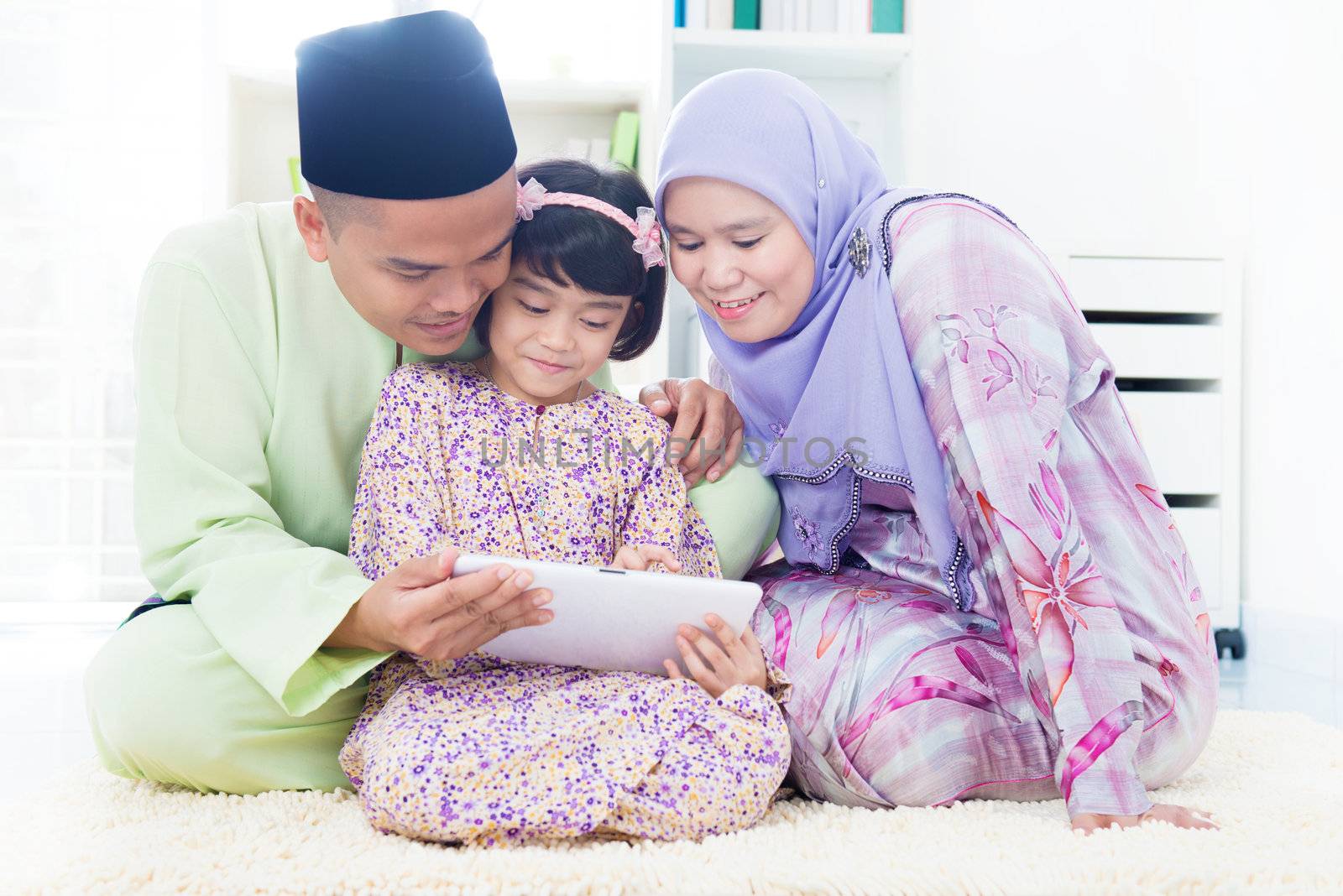 Southeast Asian family using computer internet at home. Muslim family living lifestyle