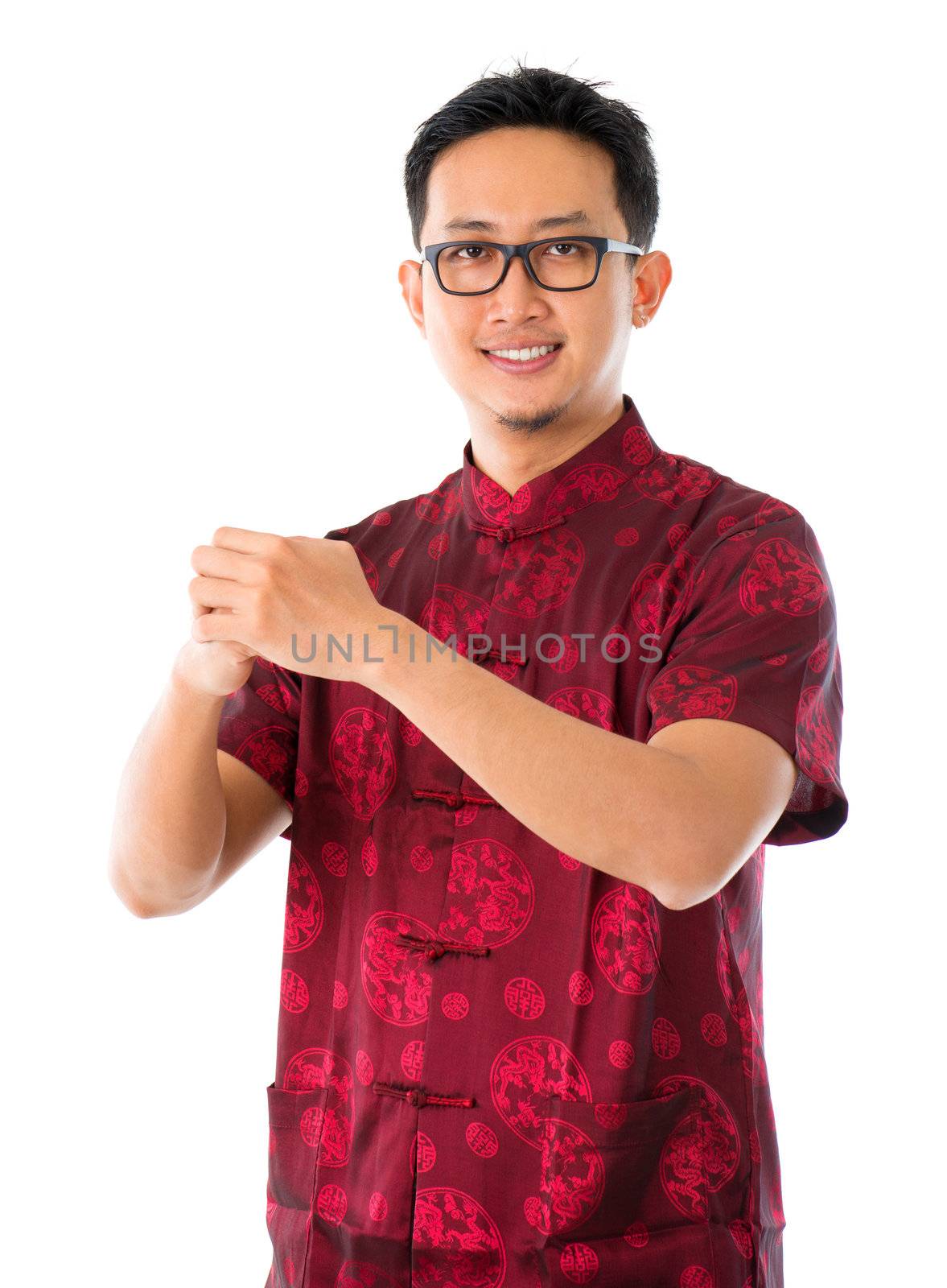 Southeast Asian Chinese man in traditional Chinese Tang suit greeting, isolated on white background