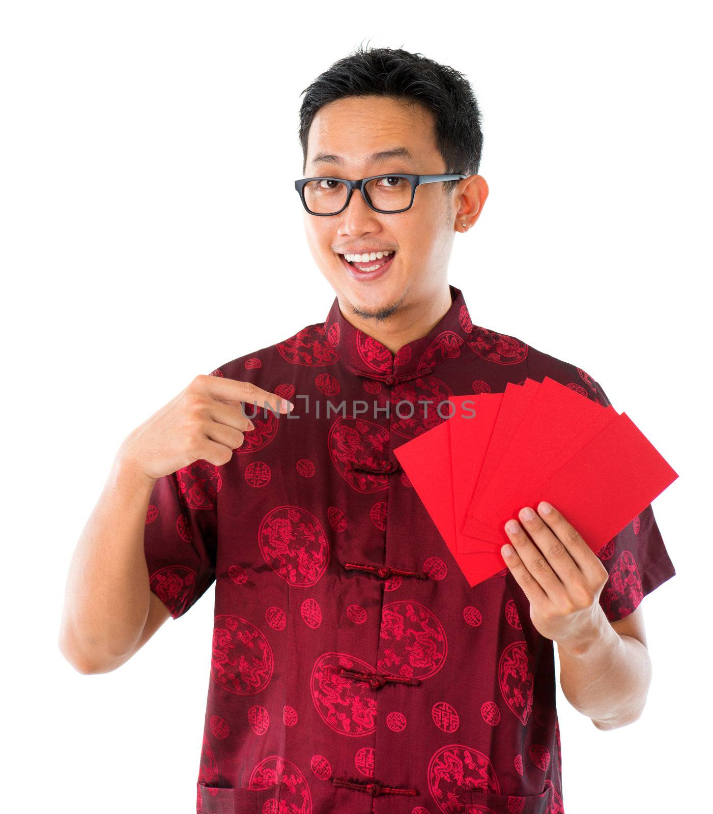 Southeast Asian Chinese male in cheongsam hands holding red packets / ang pow , isolated on white background.