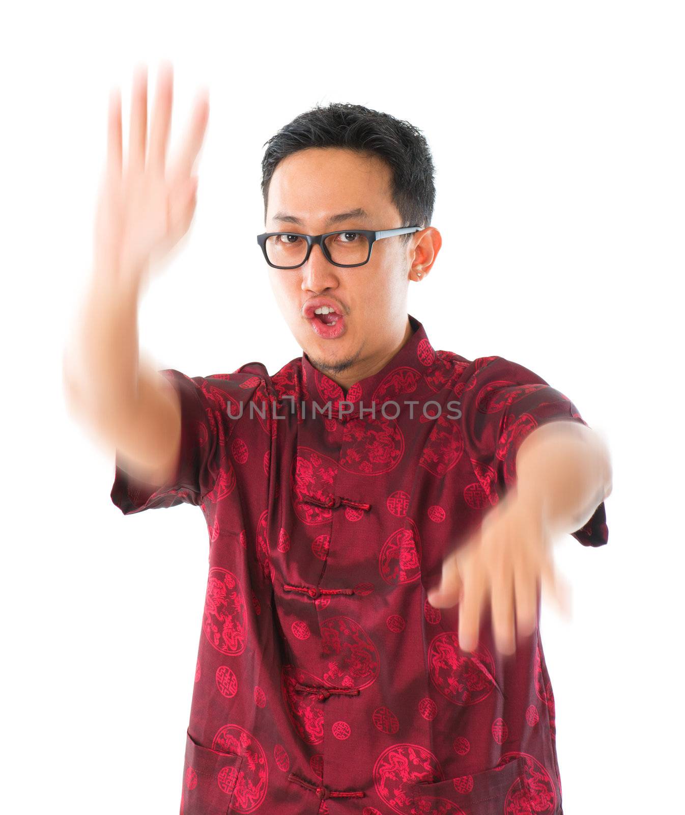 Southeast Asian Chinese man practicing wushu, isolated on white background
