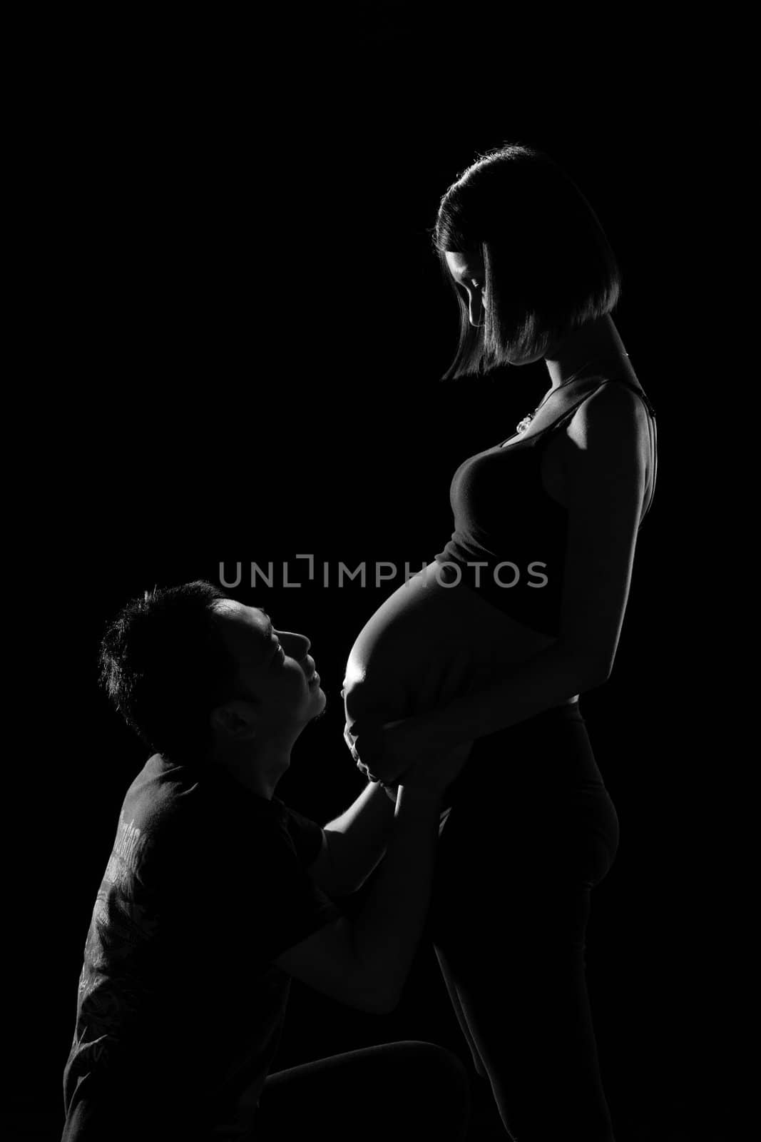 Asian couple looking at his wife, who was pregnant last week before the birth. With love and care.