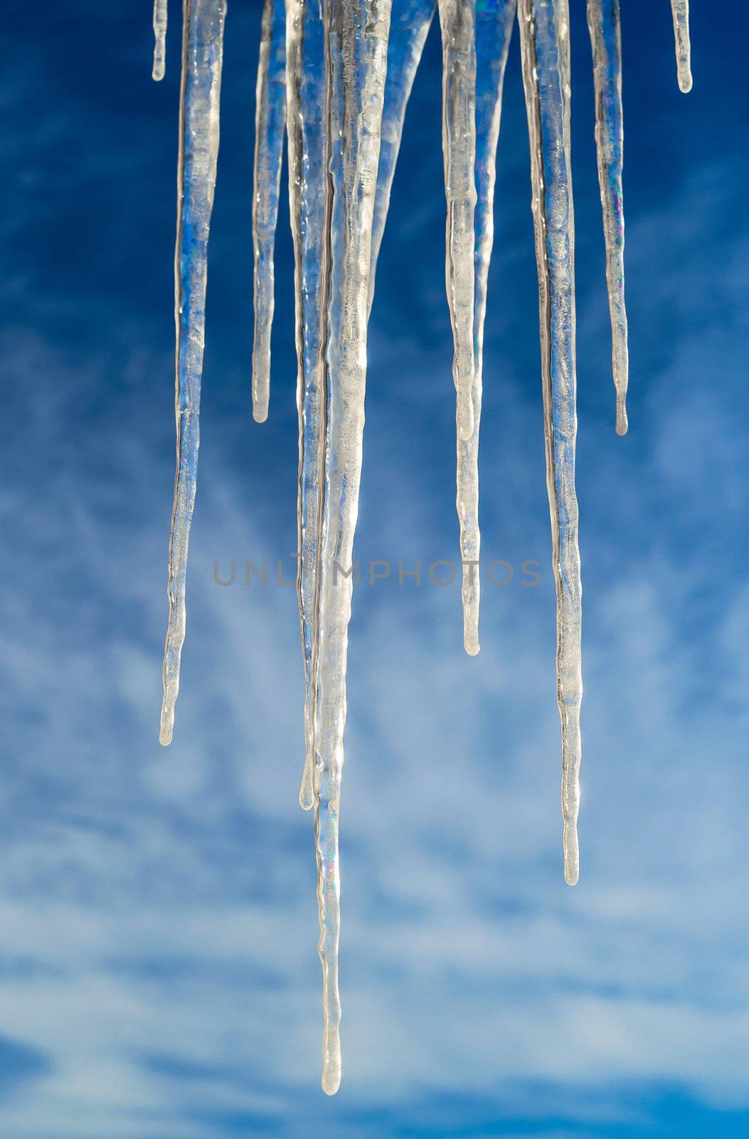 Frozen Icicles Isolated over Blue Sky with clouds