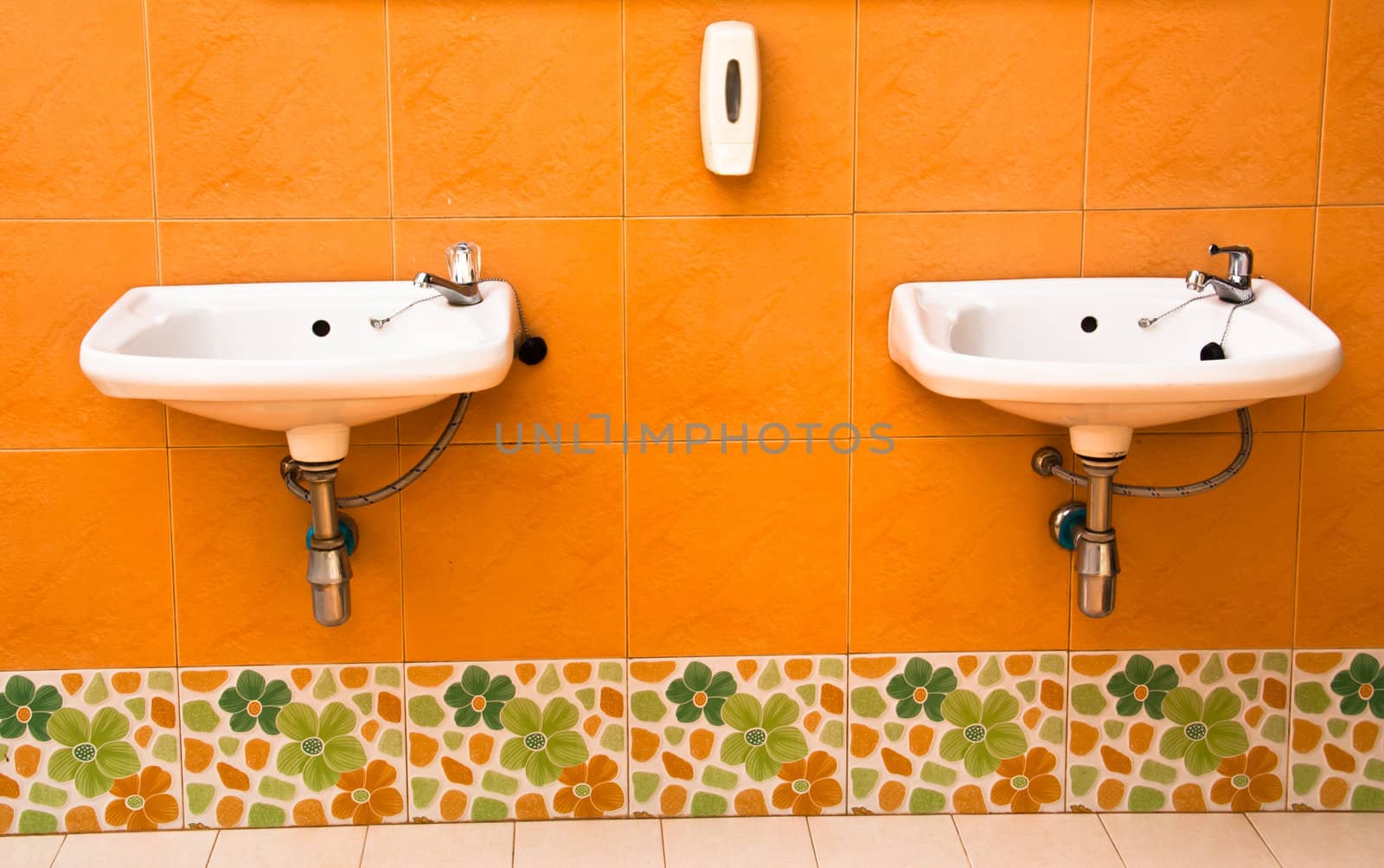 Two sinks on the wall. In the bathroom of the resort.