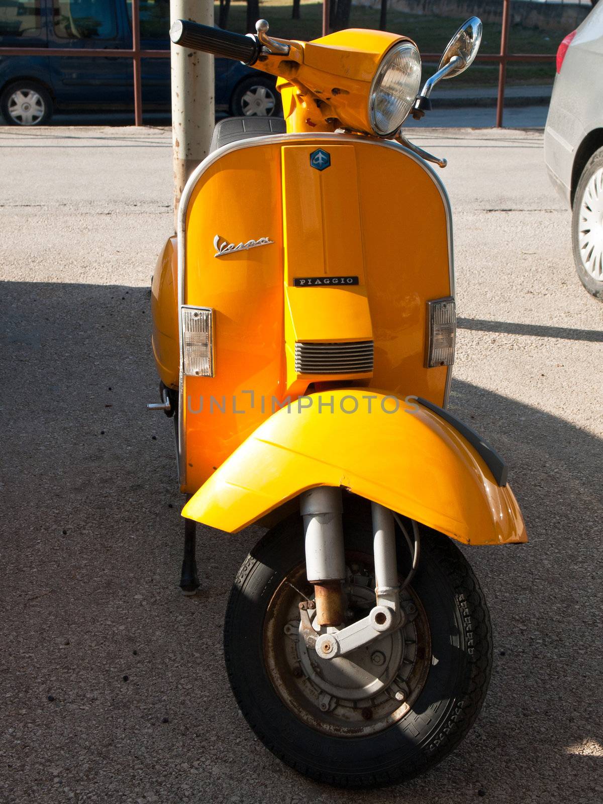 yellow vespa parked on the street