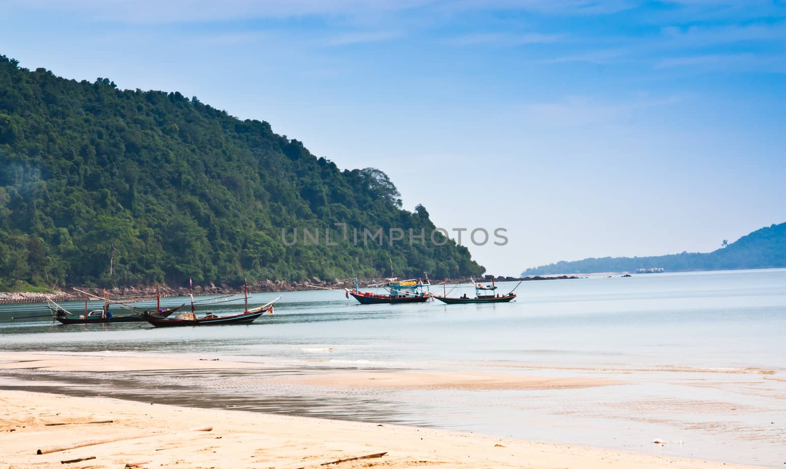 Fishing boats near the beach, which is adjacent to the mountain.