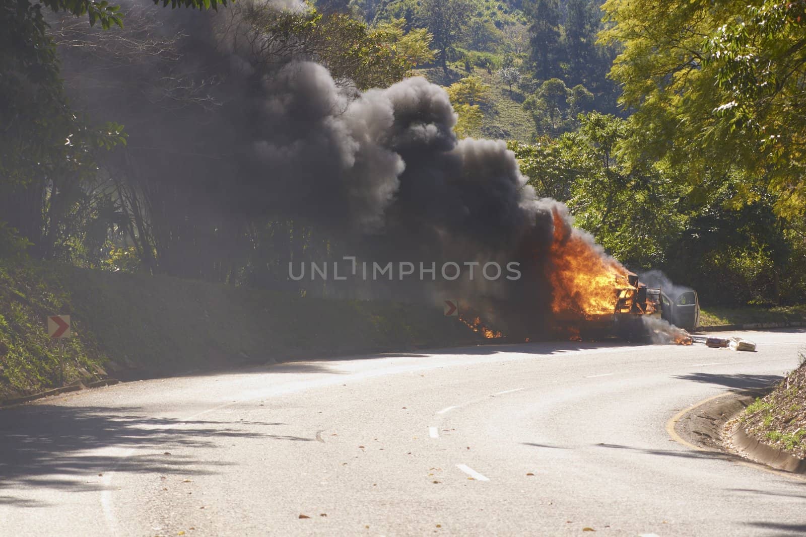 Smoke and flames billowing from a burning car