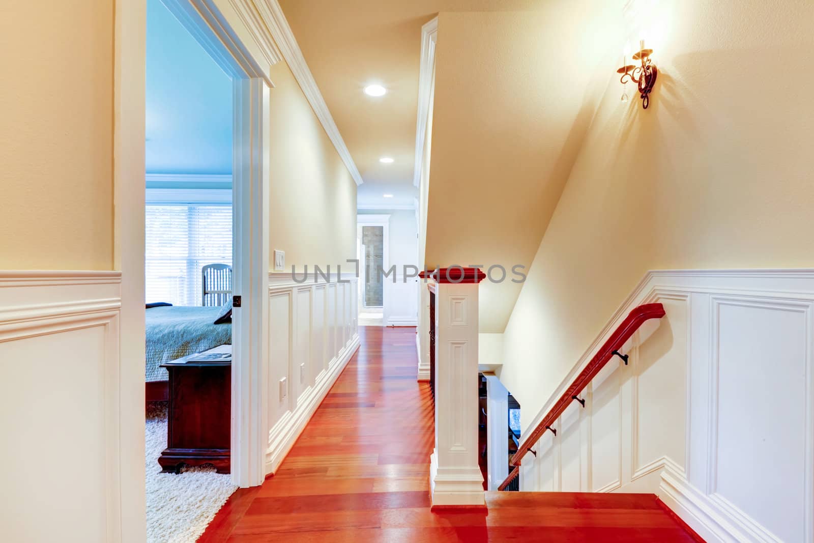 Large bright hallway with cherry hardwood and staircase.