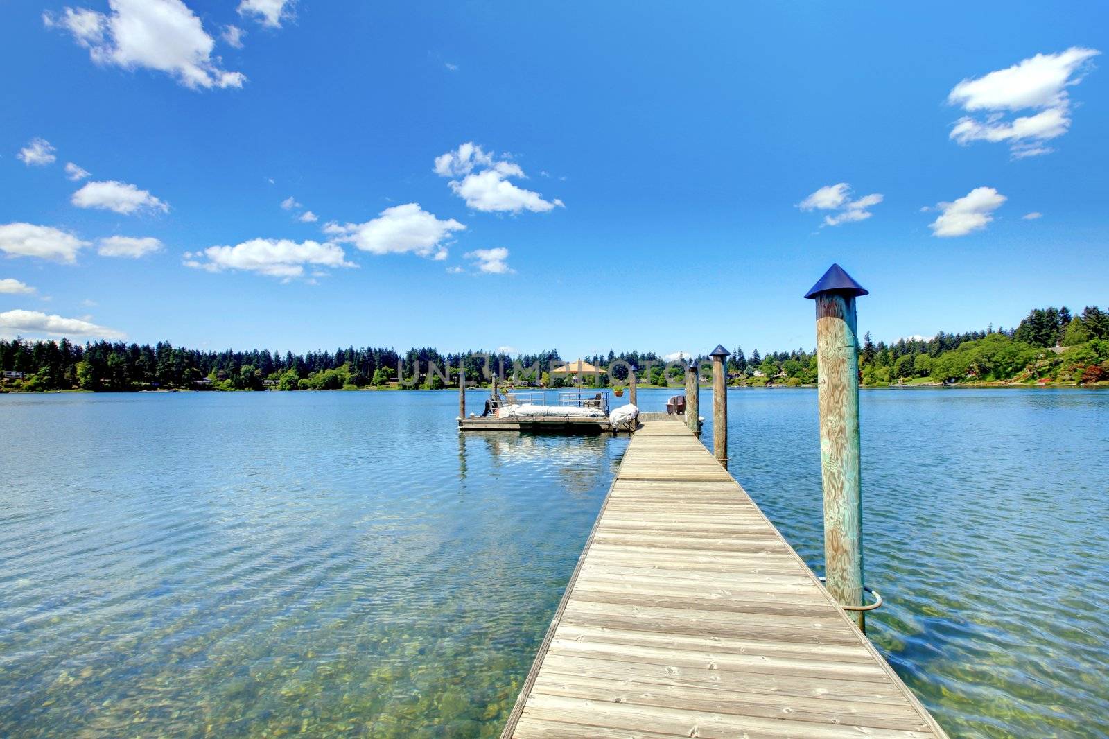 Lake with long wood pier and private party raft.