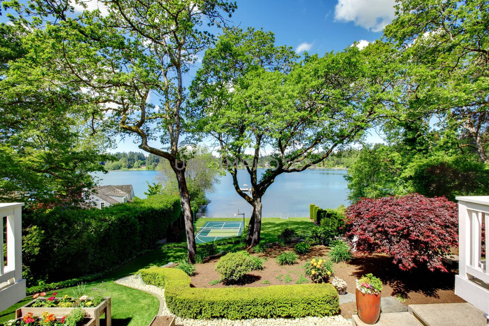 Luxury real estate lake view from home balcony with beautiful yard landscape.