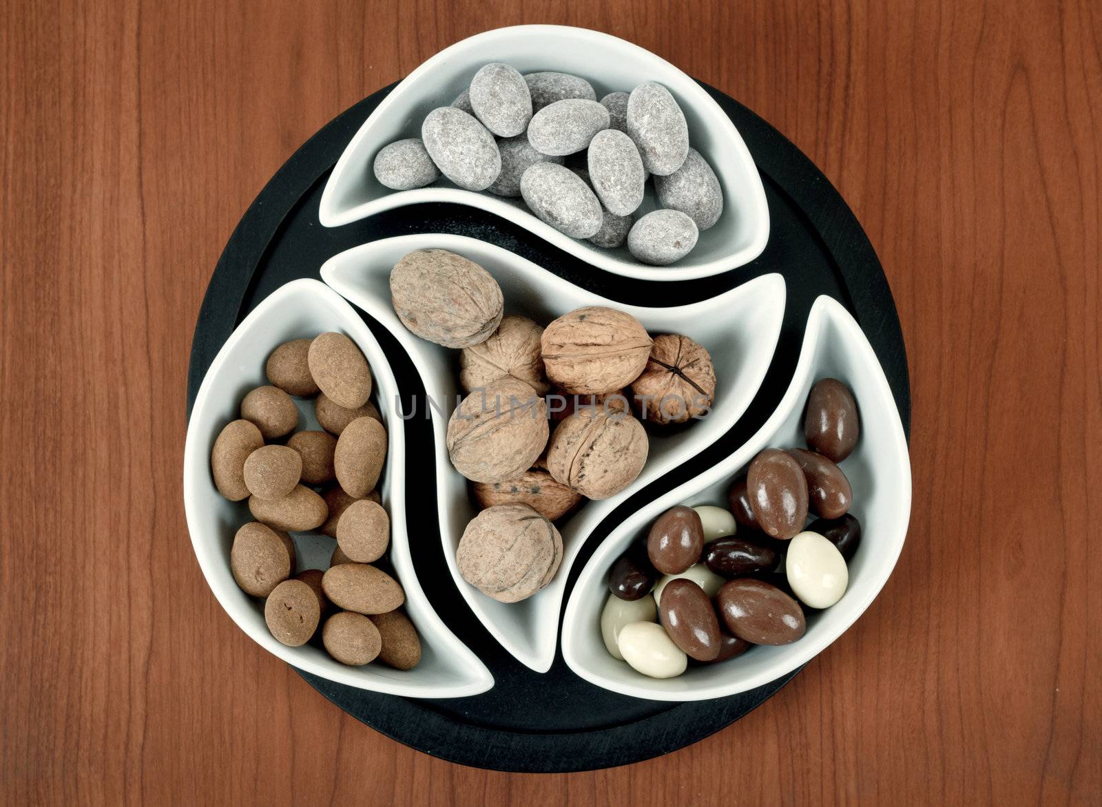 almonds in chocolate and walnuts on woden background