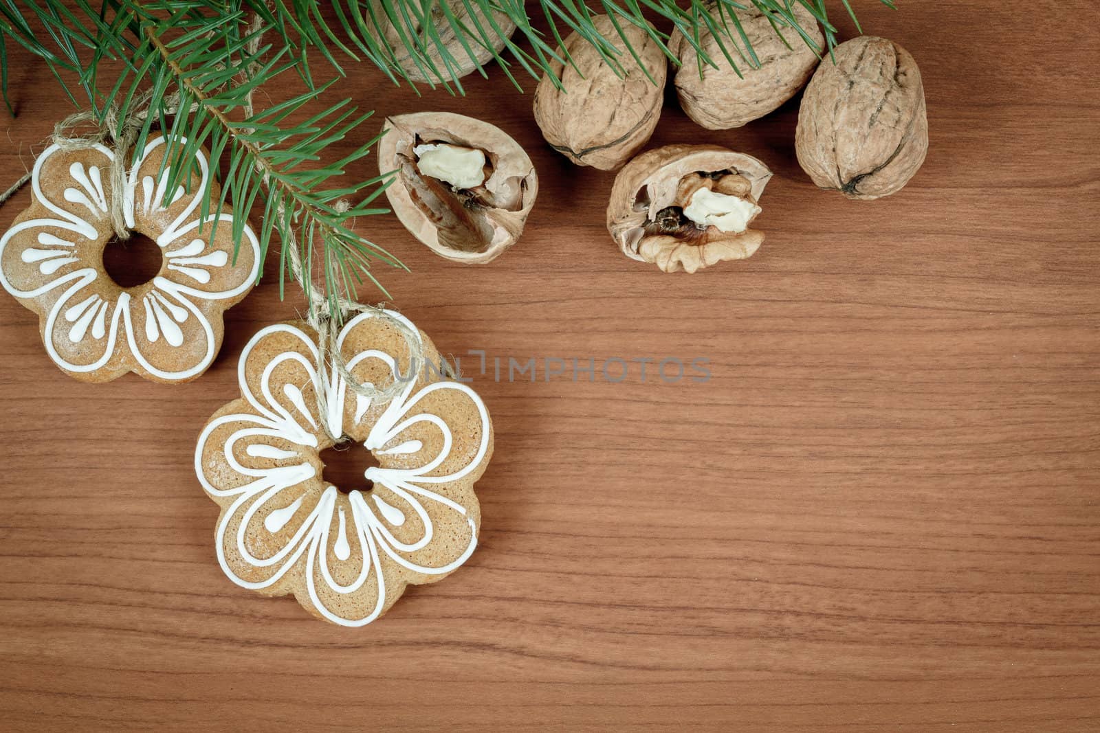 walnuts and gingerbread on wooden background with green needles