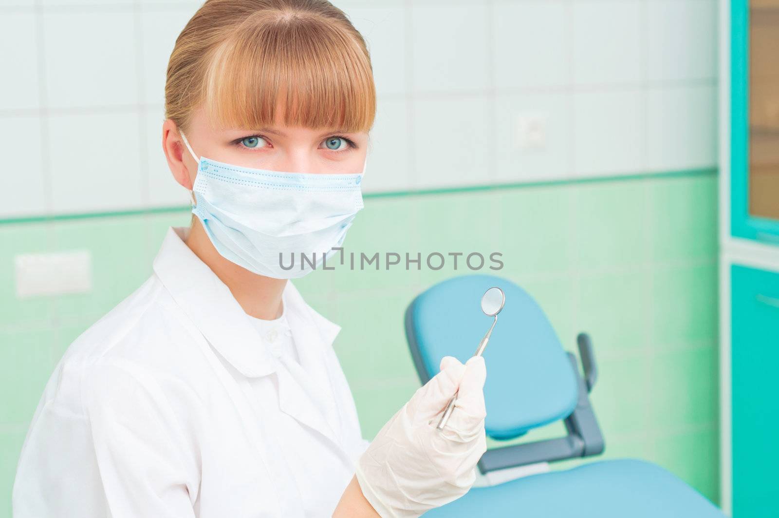 female dentists in protective mask holds a dental tool, doctors at work