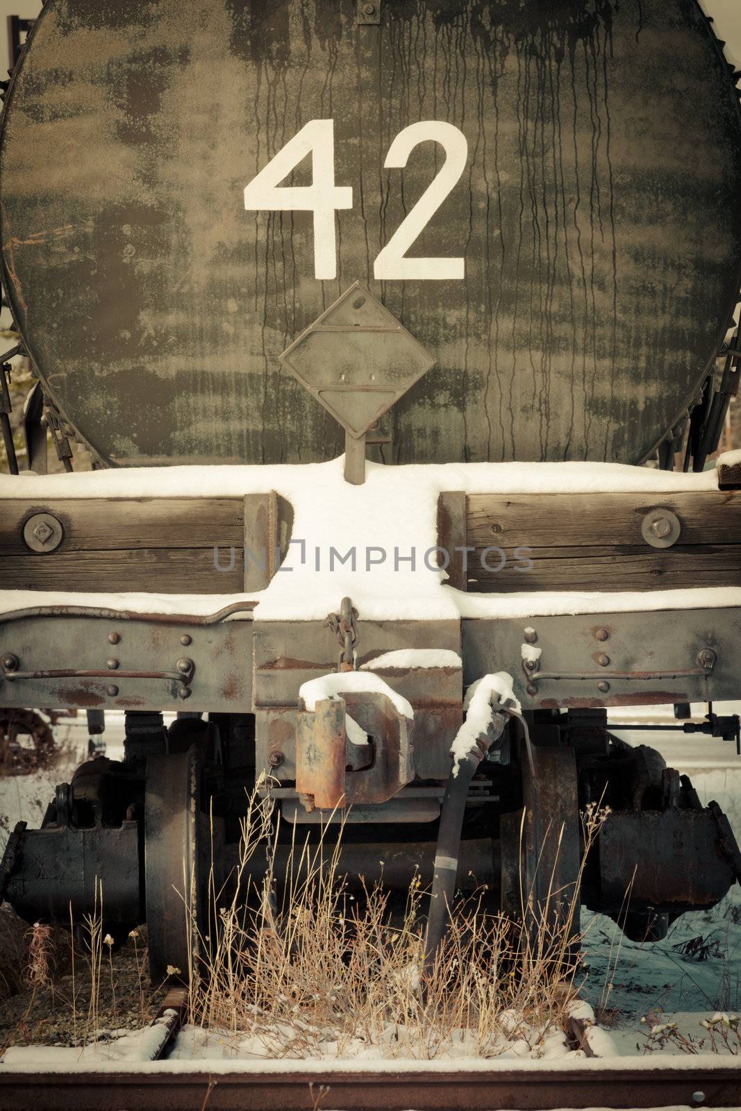 Moble photography lo-fi styled image of old obsolete railway tanker car in snowy winter with 42 written on it.