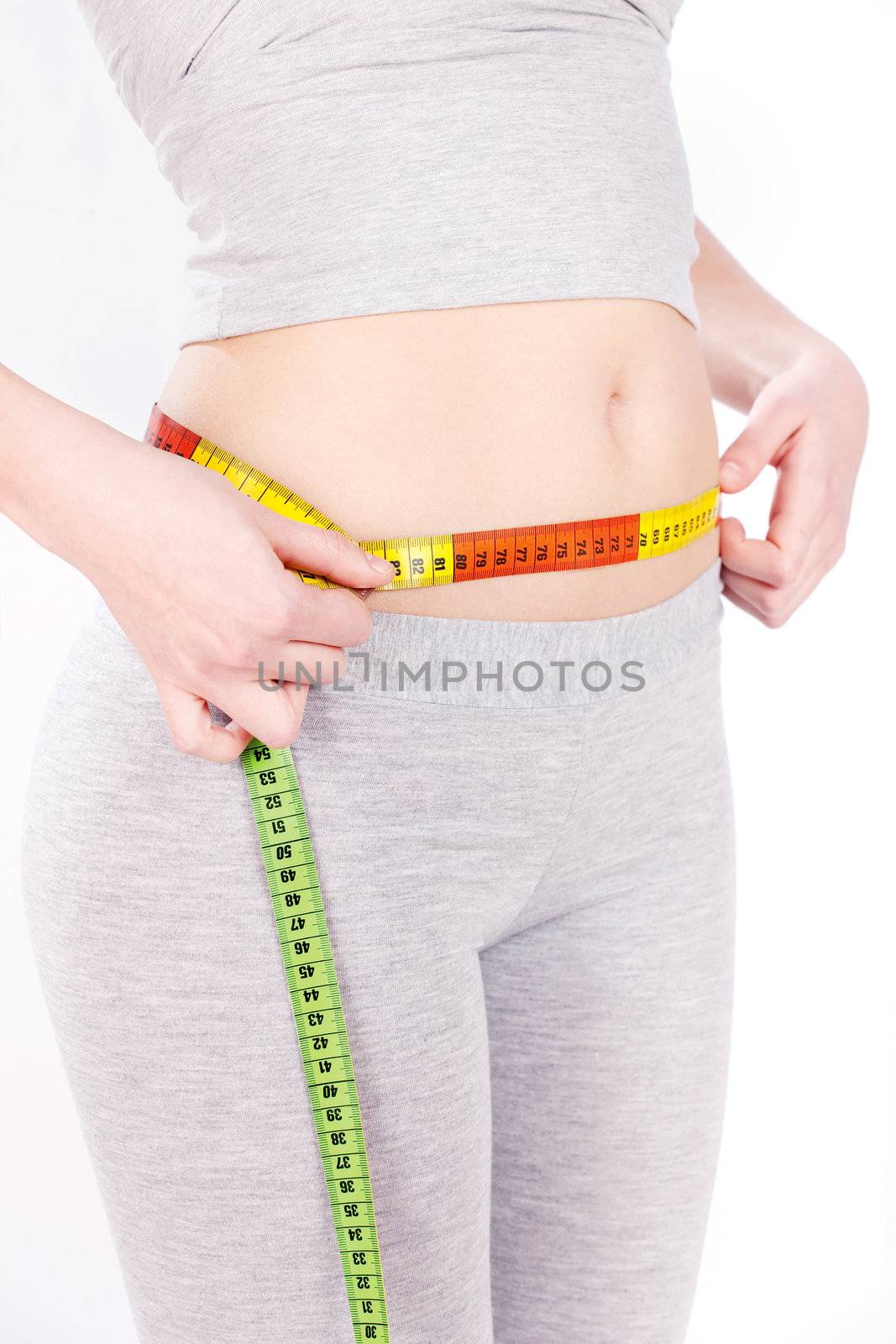 Measure tape around slim woman's waist