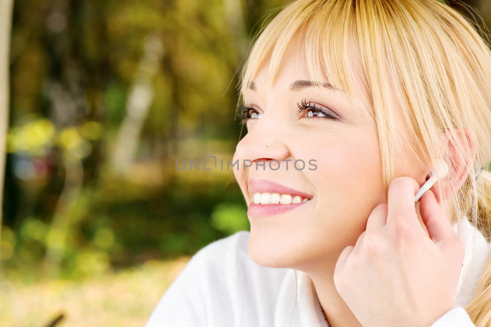 Blond woman in the park with earphones