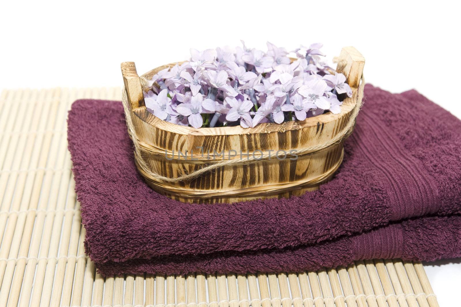 Scented soap flowers in a basket placed on two towels. Dayspa concept.