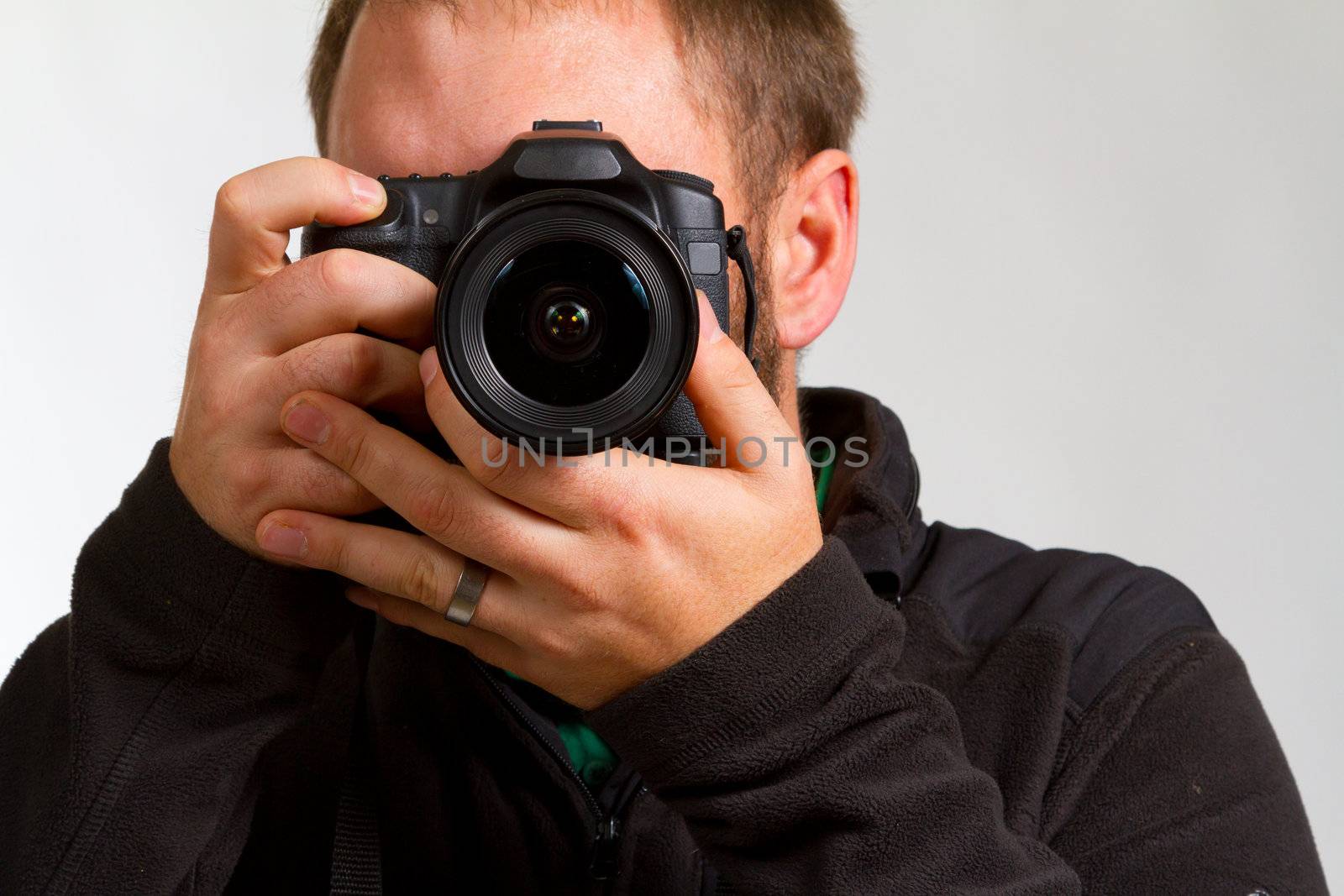 A photographer holds the camera like he is shooting photos.