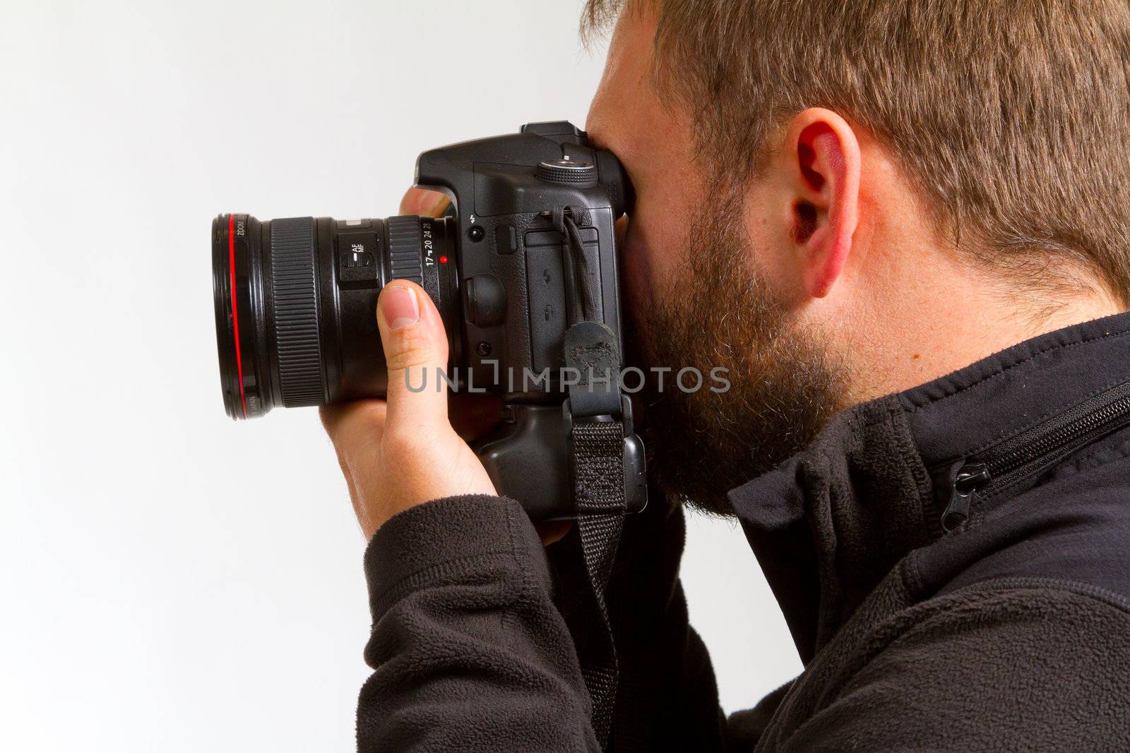 A photographer holds the camera like he is shooting photos.