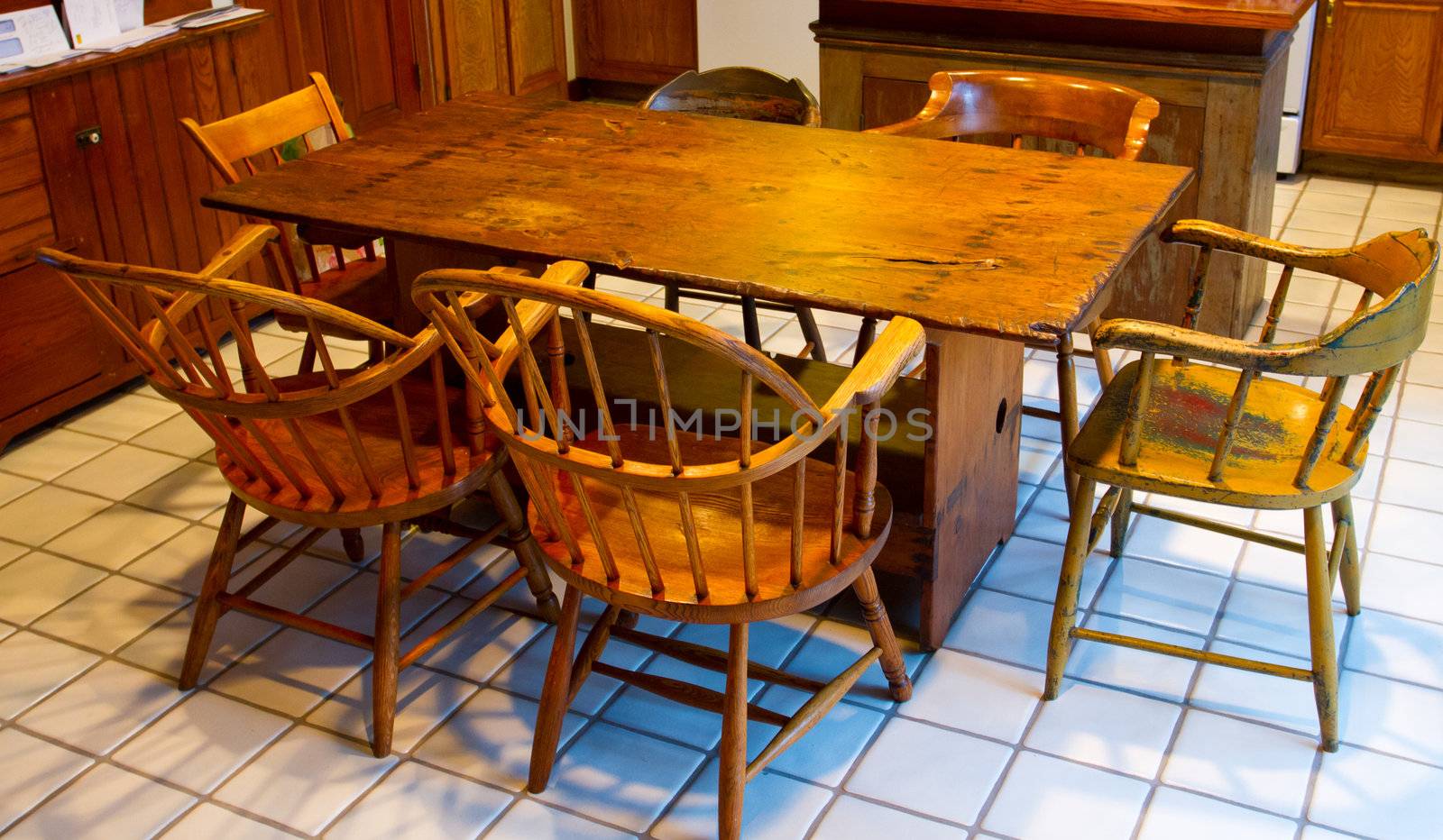 A very old antique dining set with a table and chairs in a kitchen.