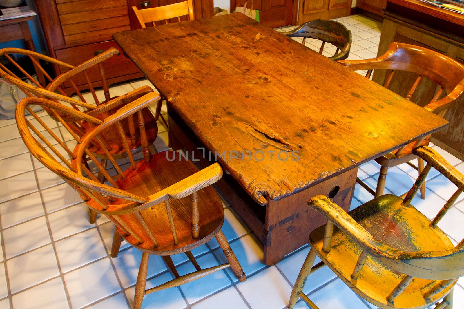 A very old antique dining set with a table and chairs in a kitchen.