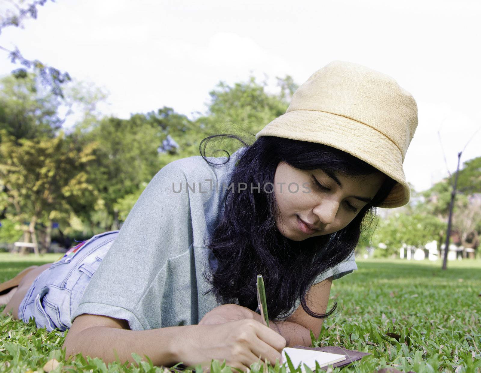 Young asia girl writting a book by siraanamwong