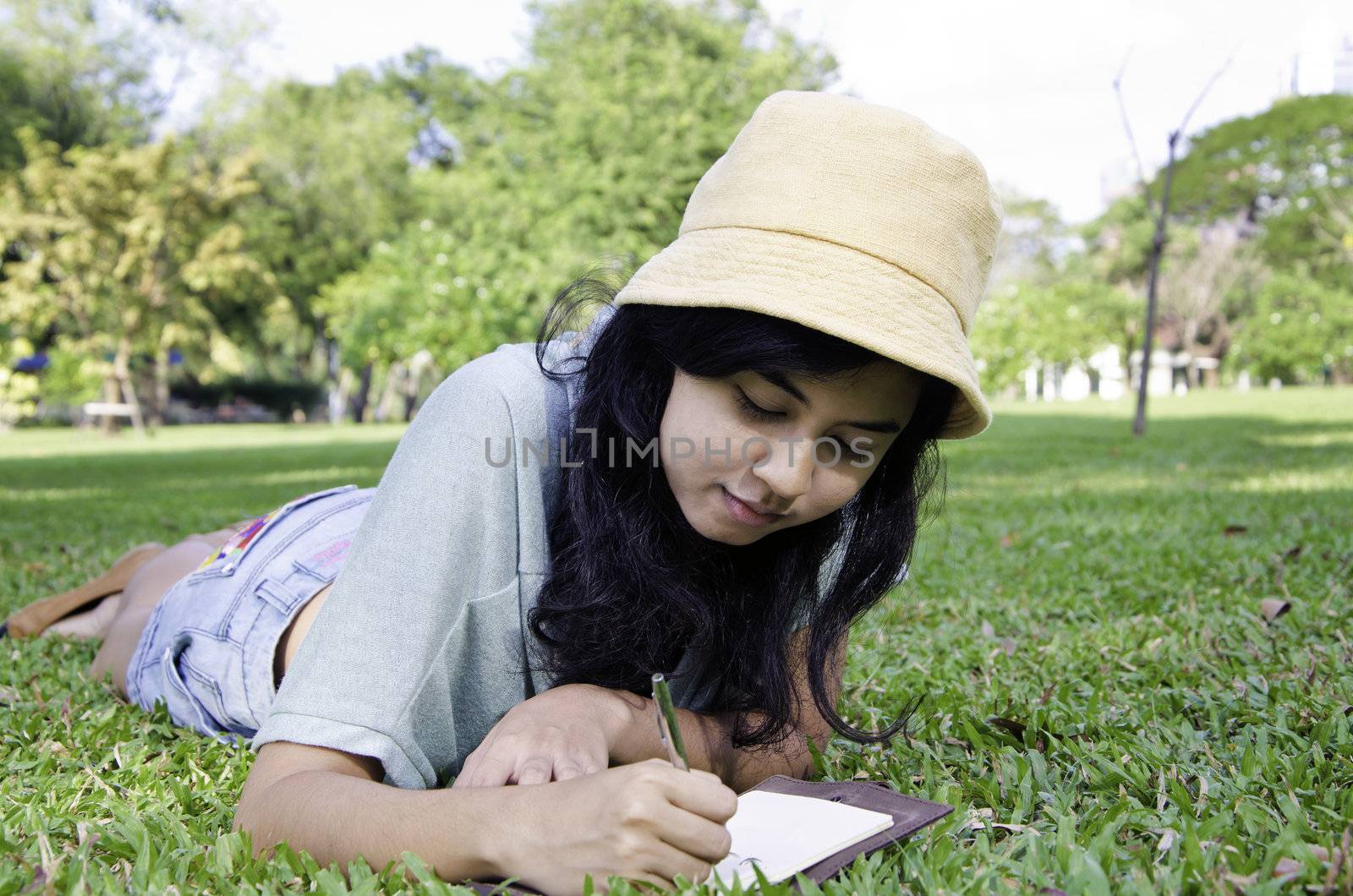 Beautiful teenage girl writting book by siraanamwong