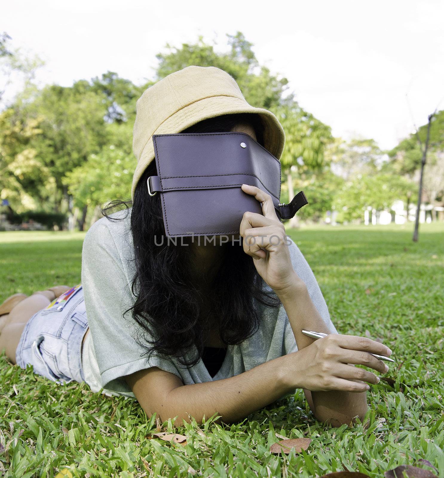woman laying on grass and thinking in park, outdoor