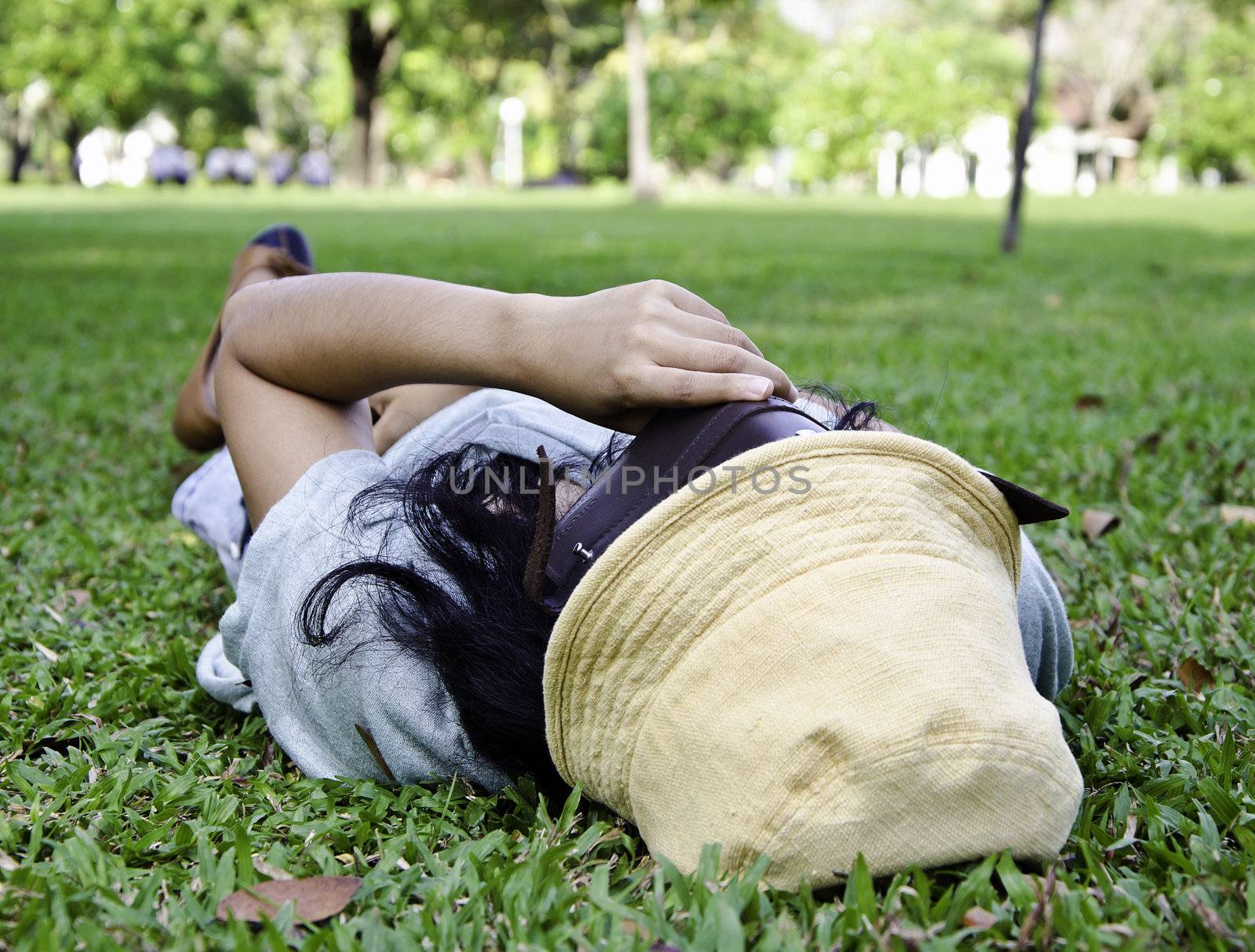 Exhausted student over the grass in the park 