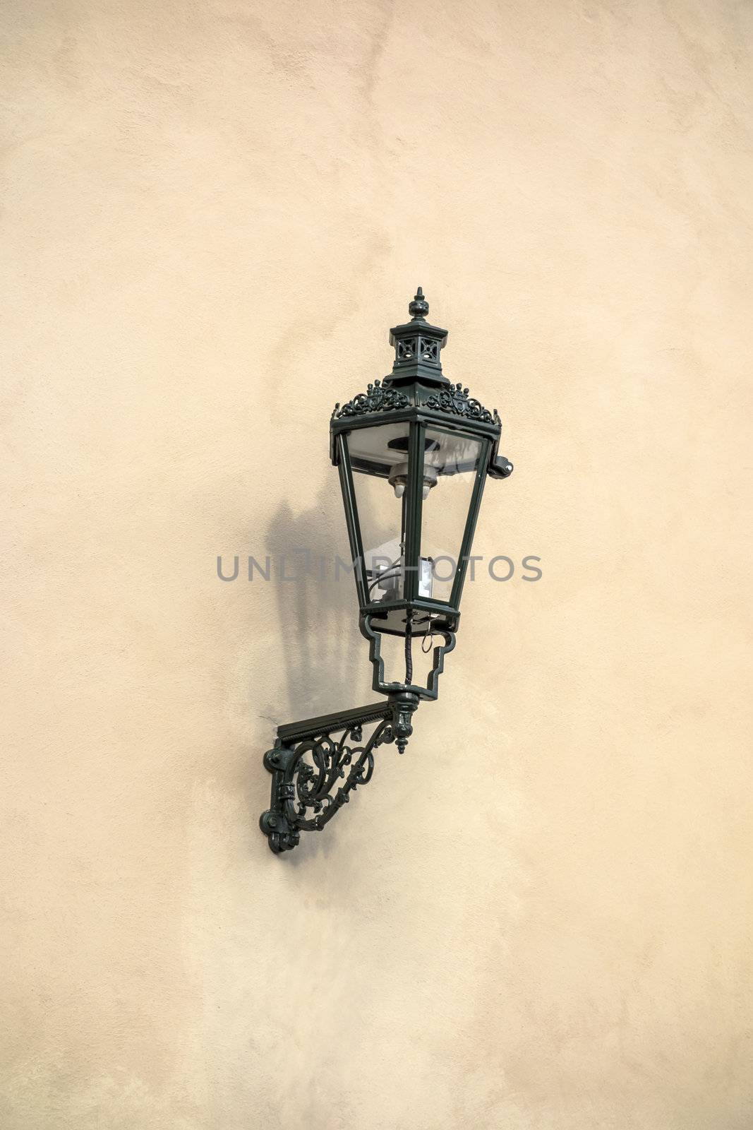 Old street light closeup on stone wall in Prague
