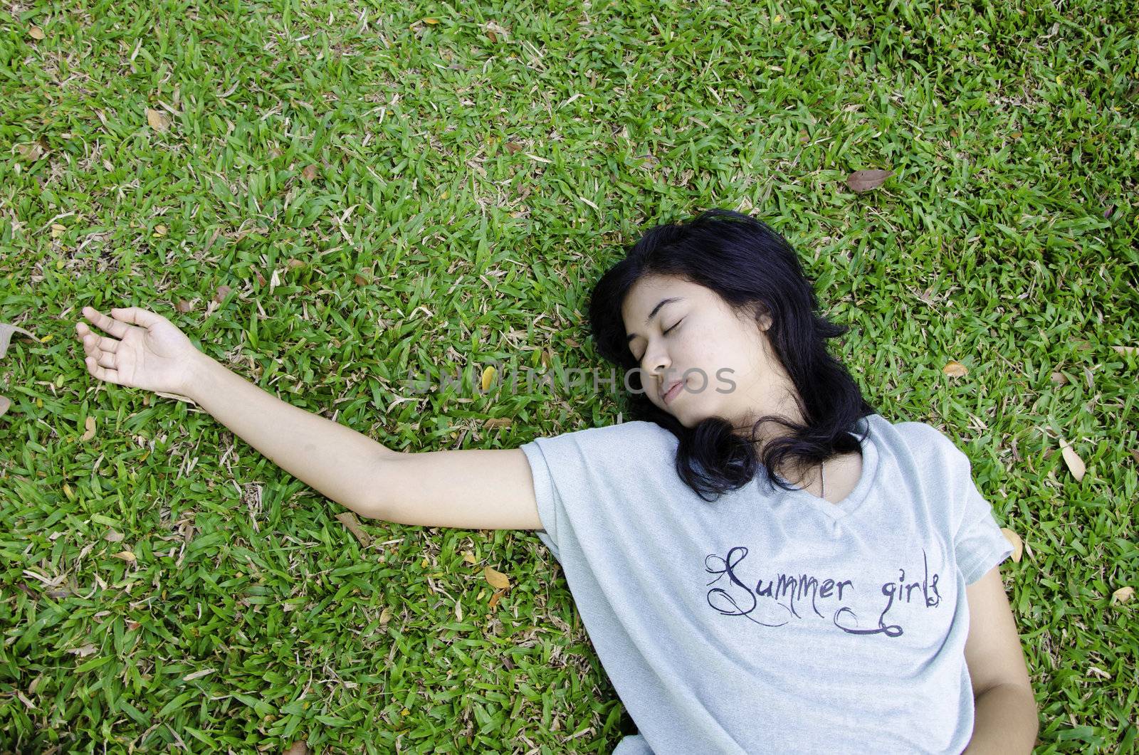 Young asian model laying in the grass 
