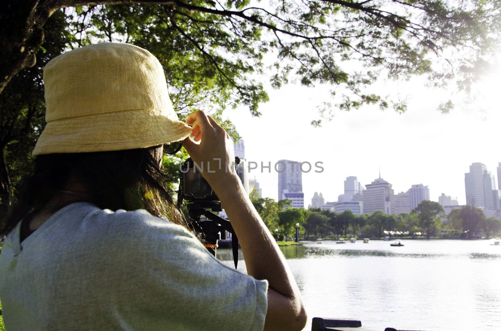 Girl taking photos by professional digital camera in lumpini park , bangkok, thailand