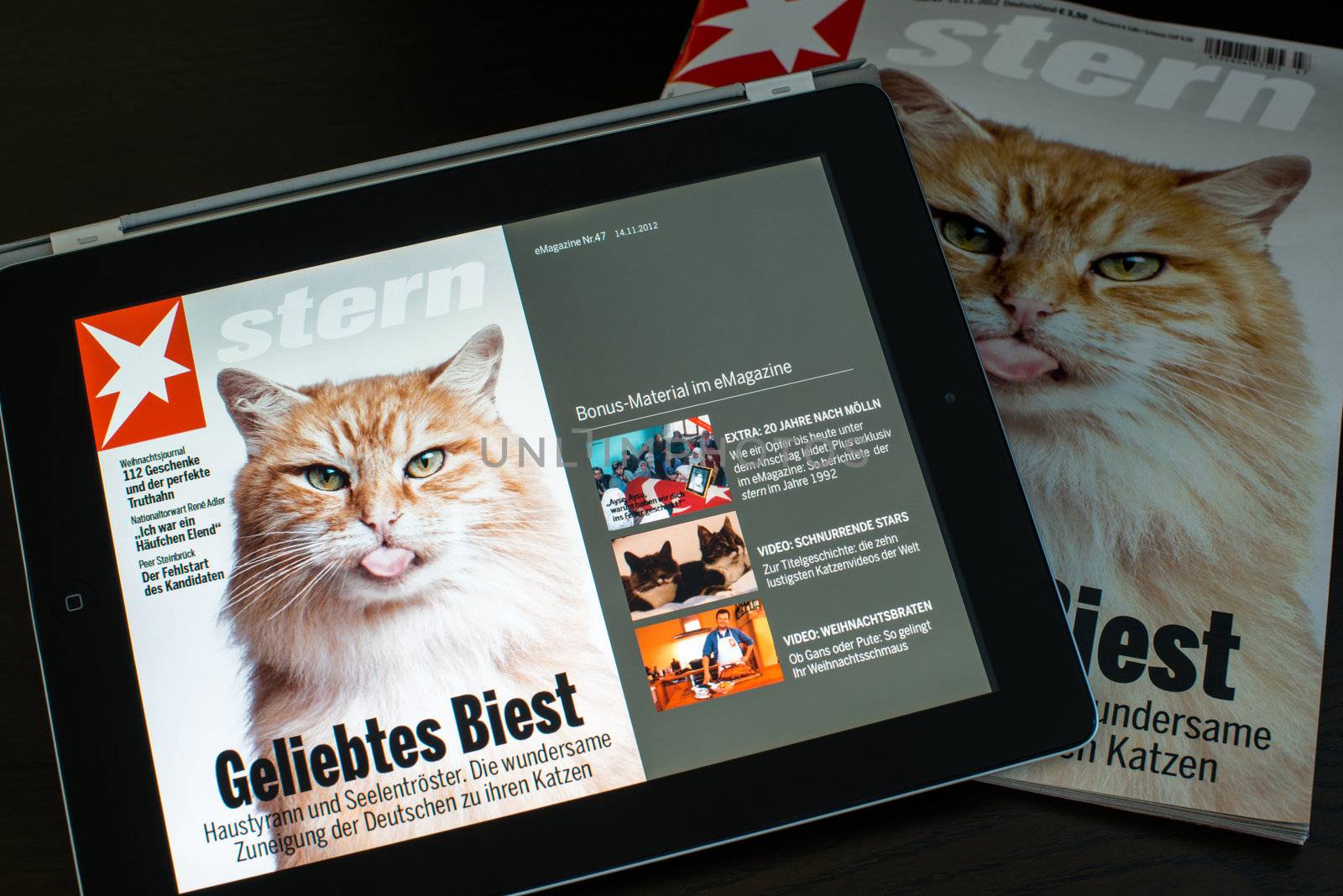 STUTTGART - NOVEMBER 18, 2012: The latest Stern e-Magazine is opened on an Apple iPad next to the printed version on November 18, 2012 in Stuttgart, Germany. Stern offers additional contents such as video interviews in addition to their weekly print-magazine.