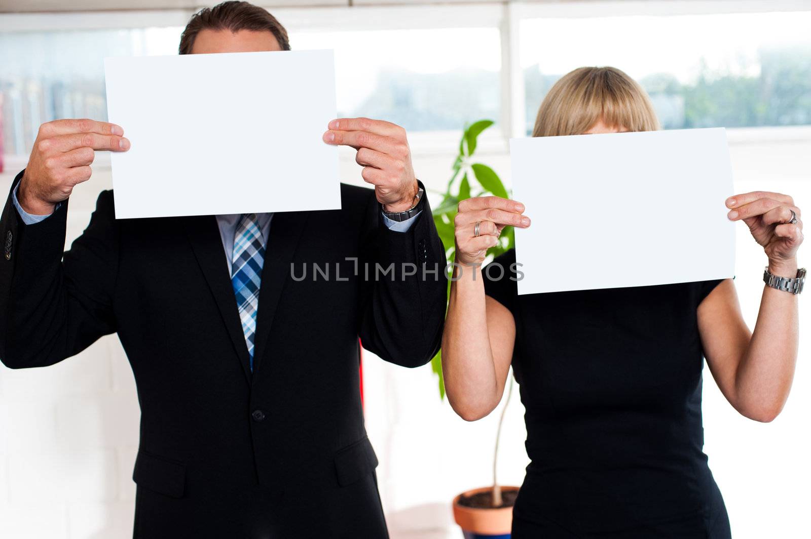 Boss and secretary each holding blank banner ad in front of their face.