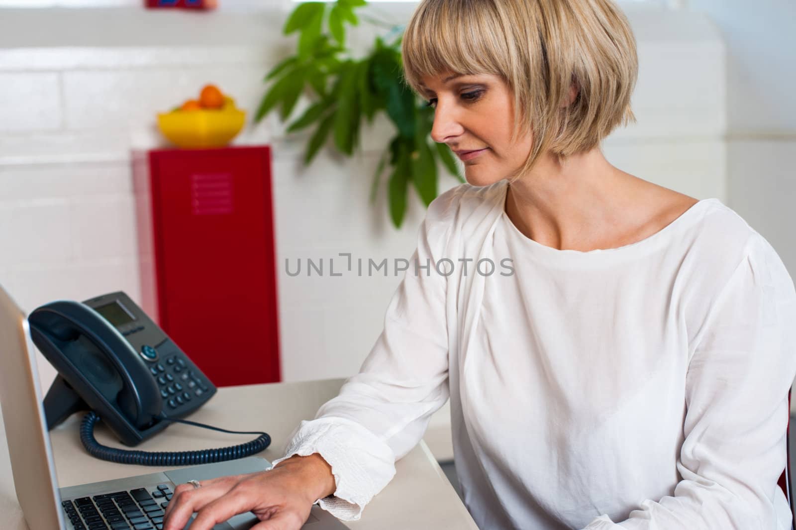 Tired looking female working on a laptop. Long day at work.