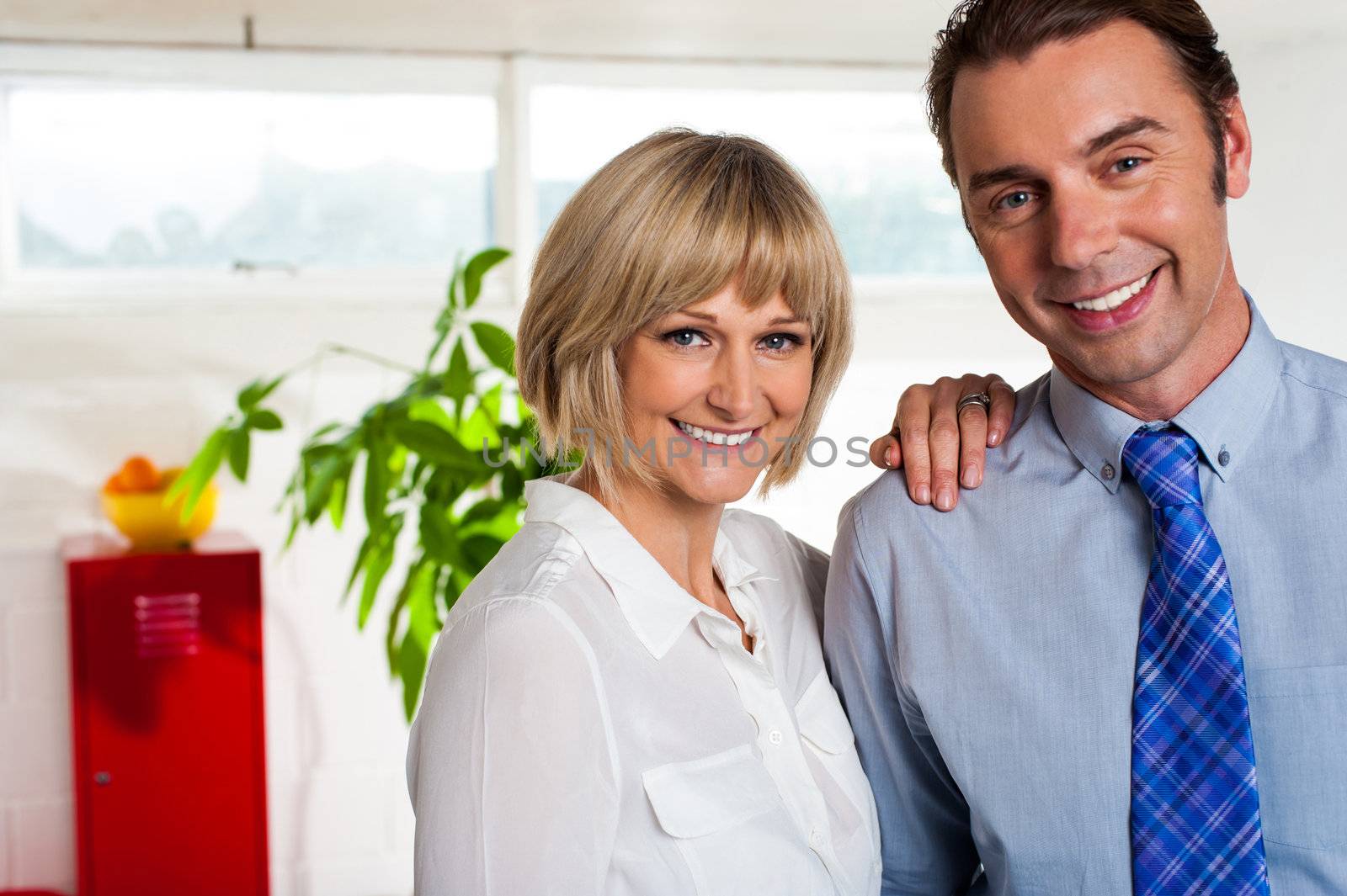 Man and woman. Business couple posing together in their new office.