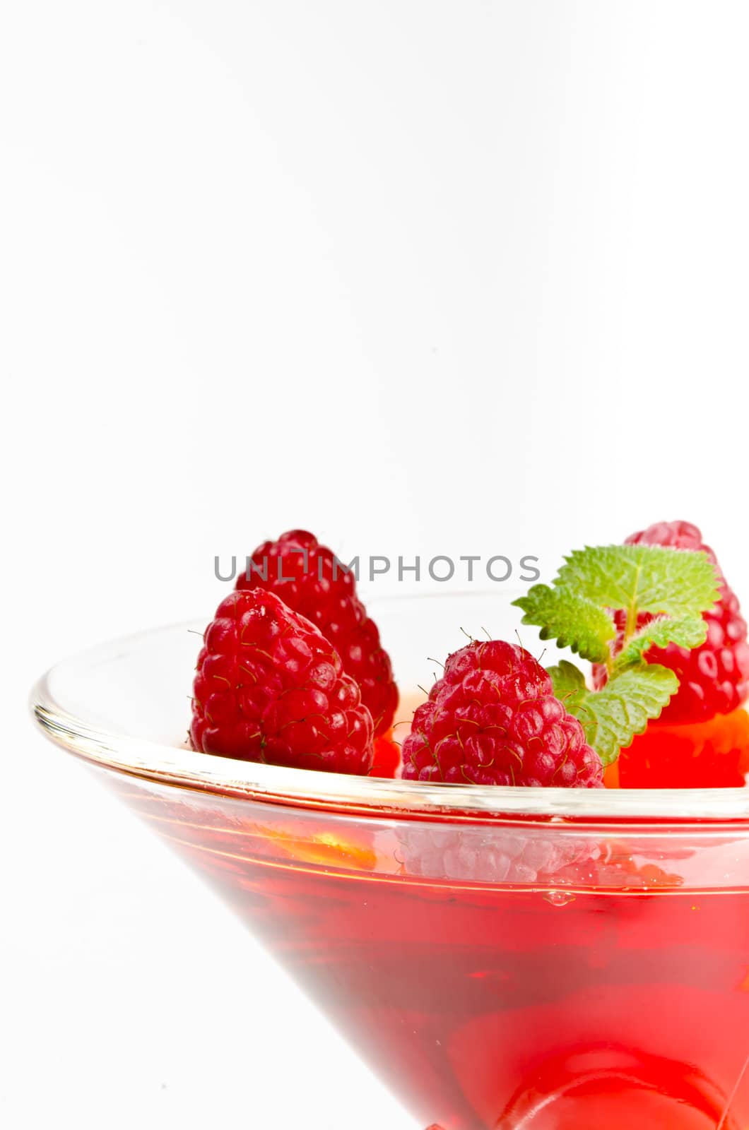 Fruit jelly in the glass bowls with fresh raspberries