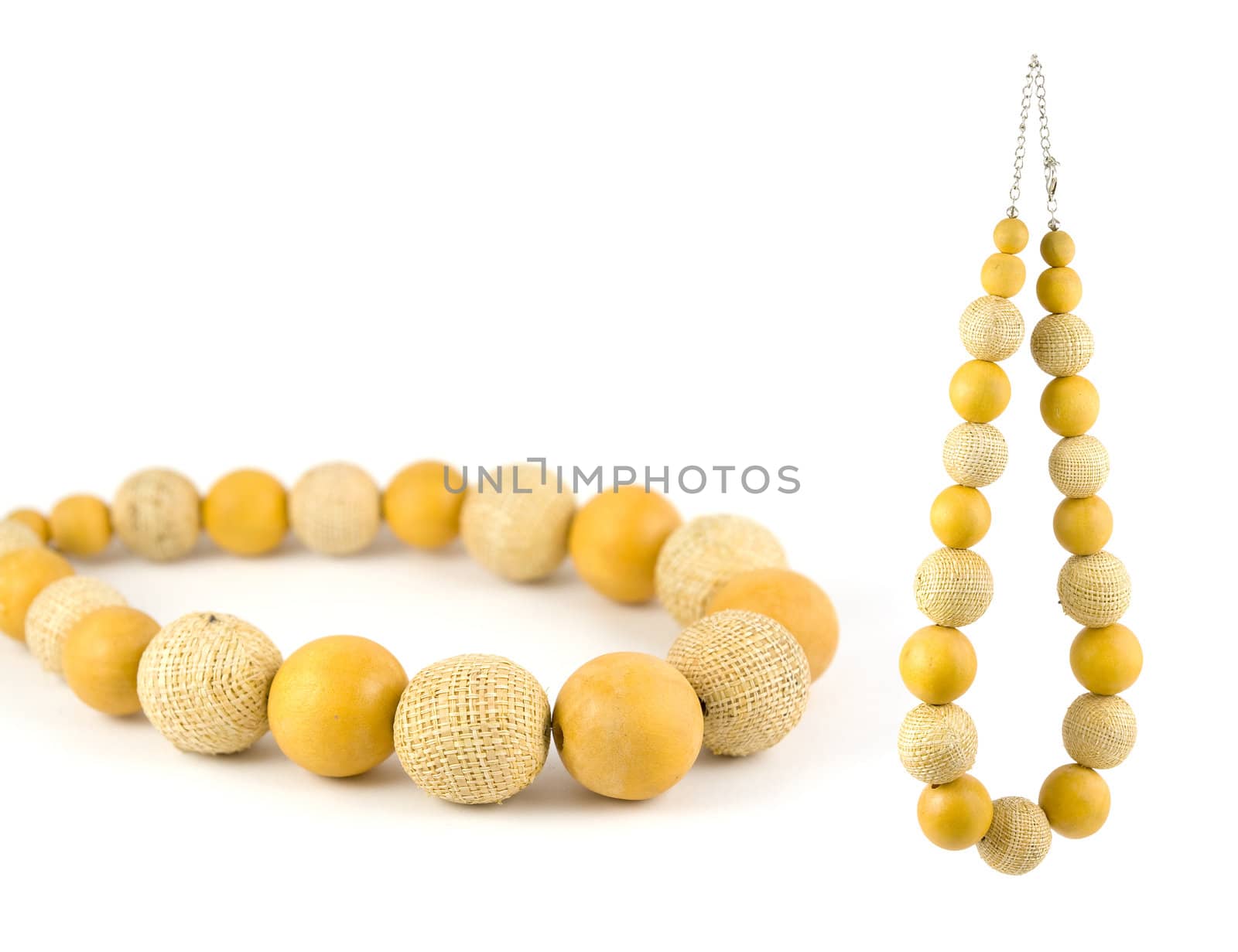 Lovely necklace made from yellow wooden balls and balls made of cloth. Isolated on pure white background. Copy-space.