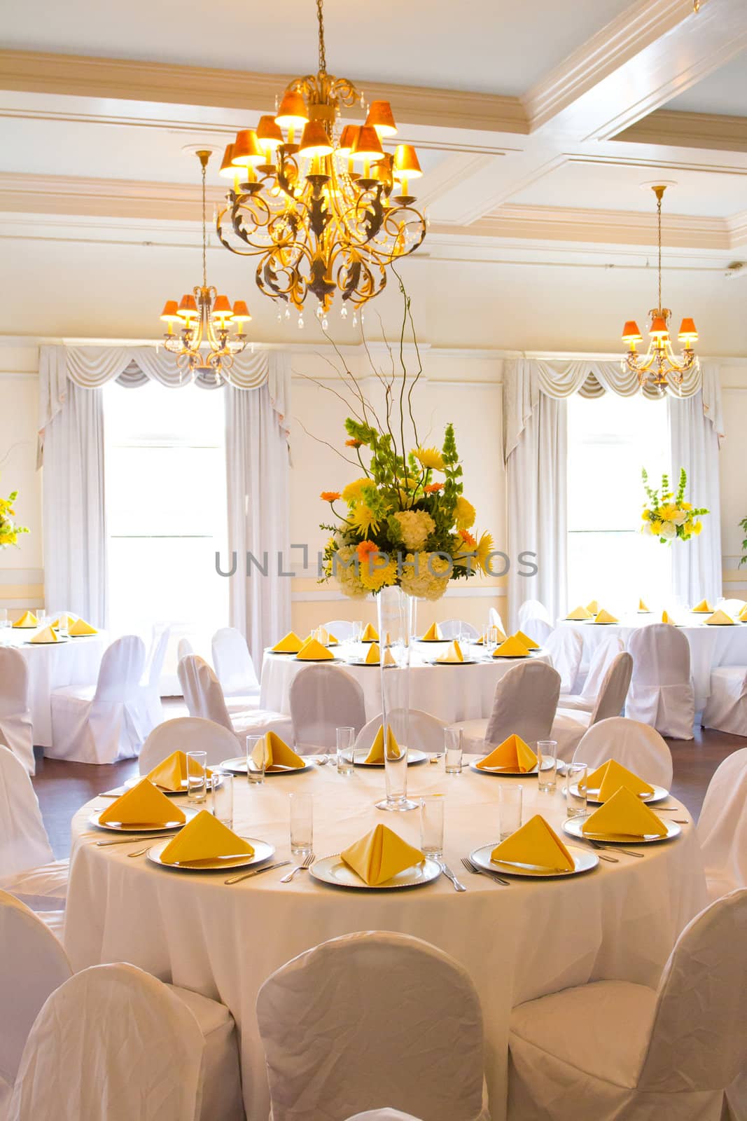 Place settings, tables, and chairs are empty before the guests arrive at a wedding reception.