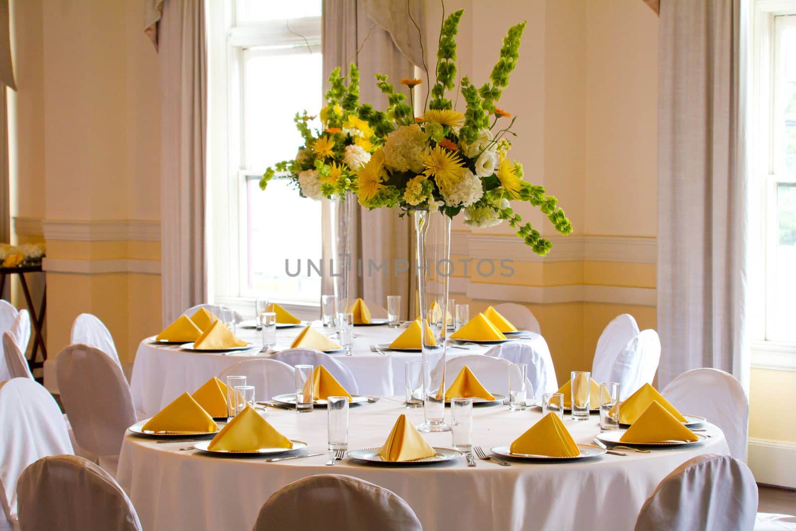 Place settings, tables, and chairs are empty before the guests arrive at a wedding reception.