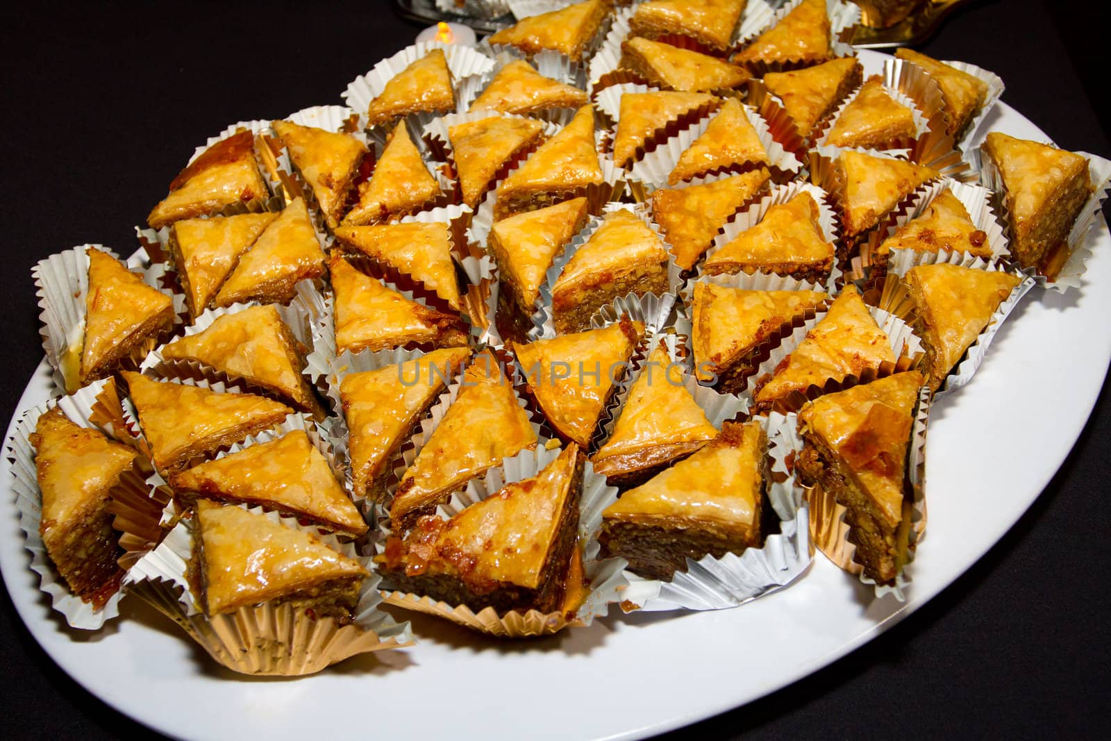 The Greek dessert baklava is individually wrapped and set on a platter at a wedding reception.