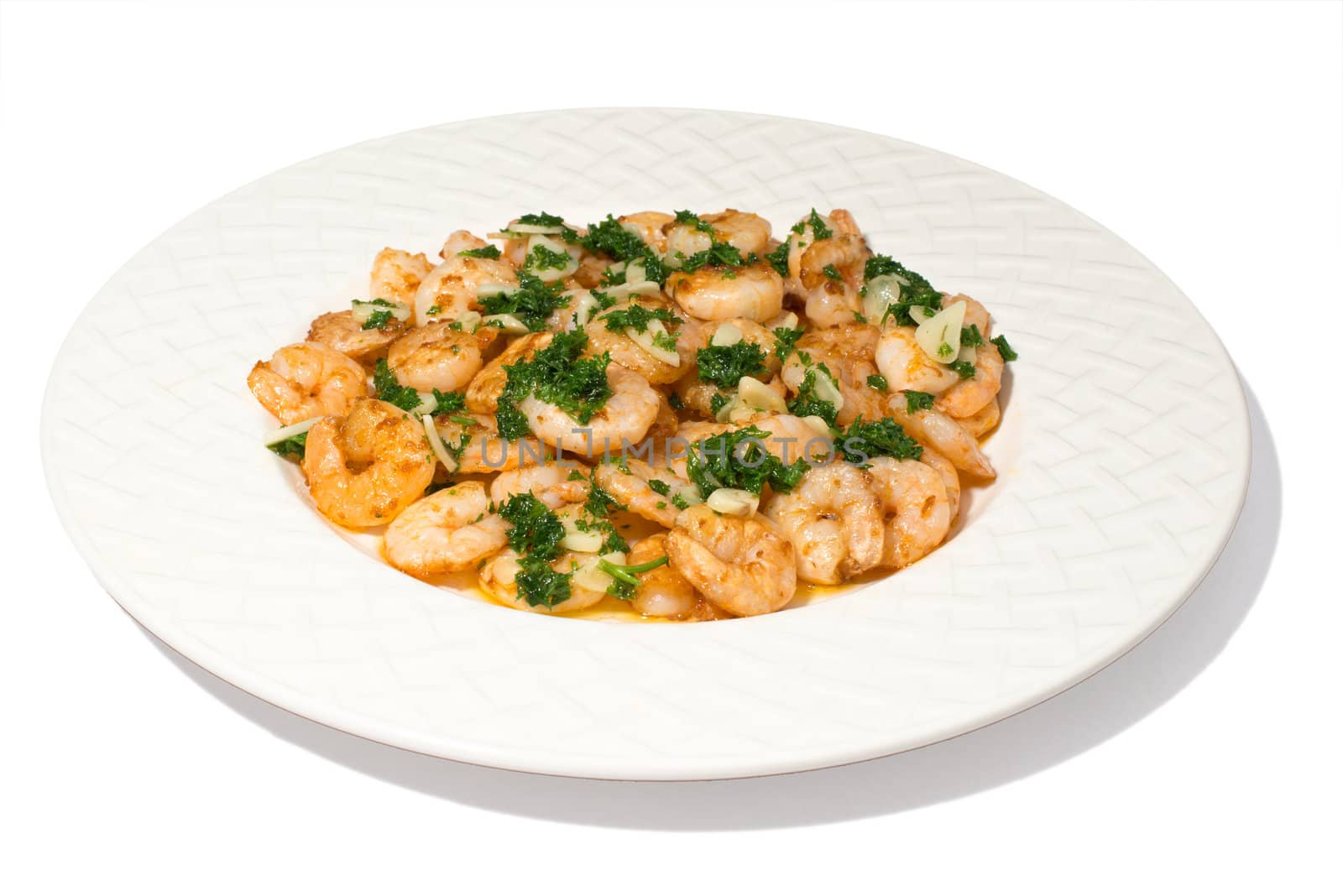 fried king prawns with garlic and herbs on a white plate isolated on white background