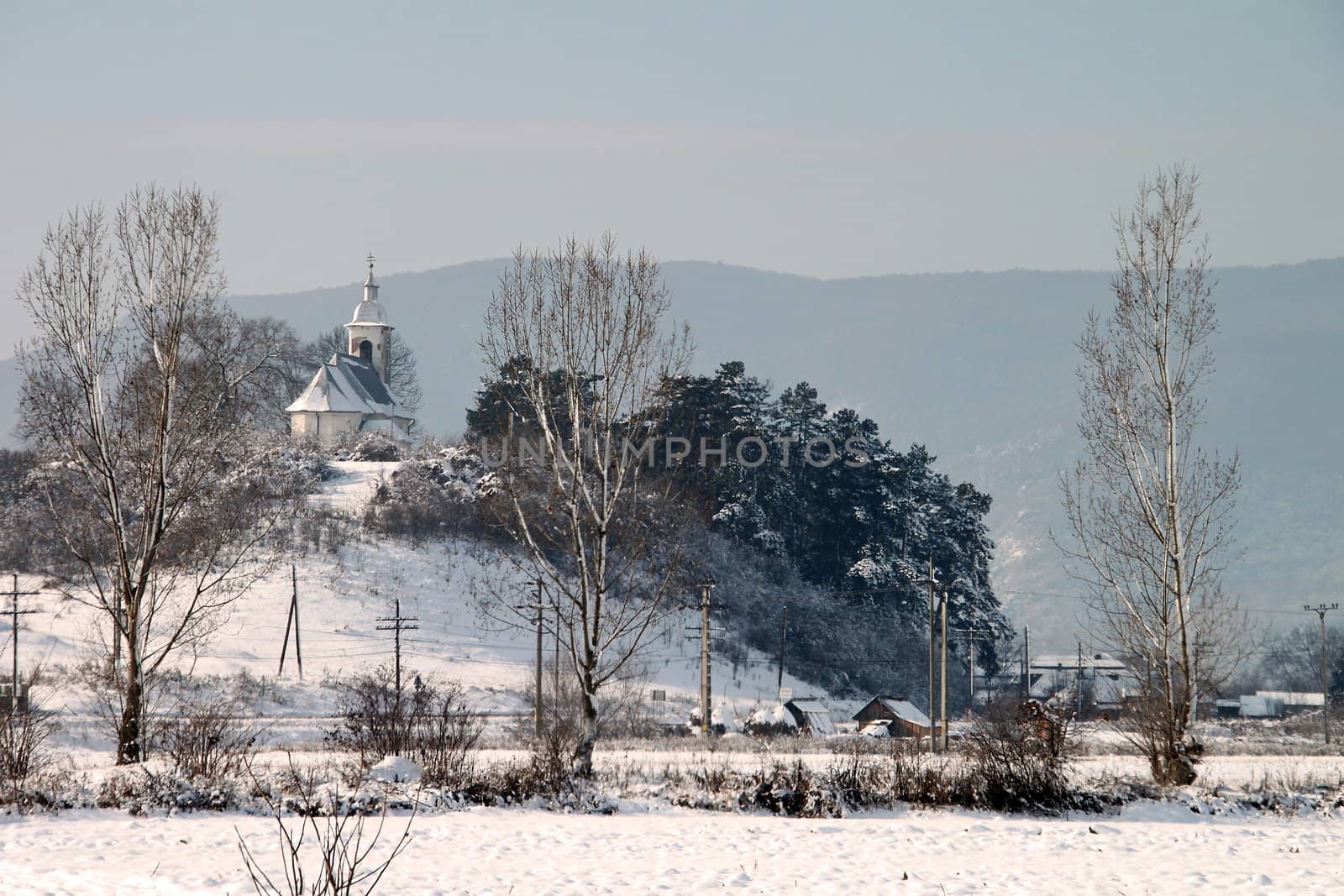 Winter landscape with trees and a church