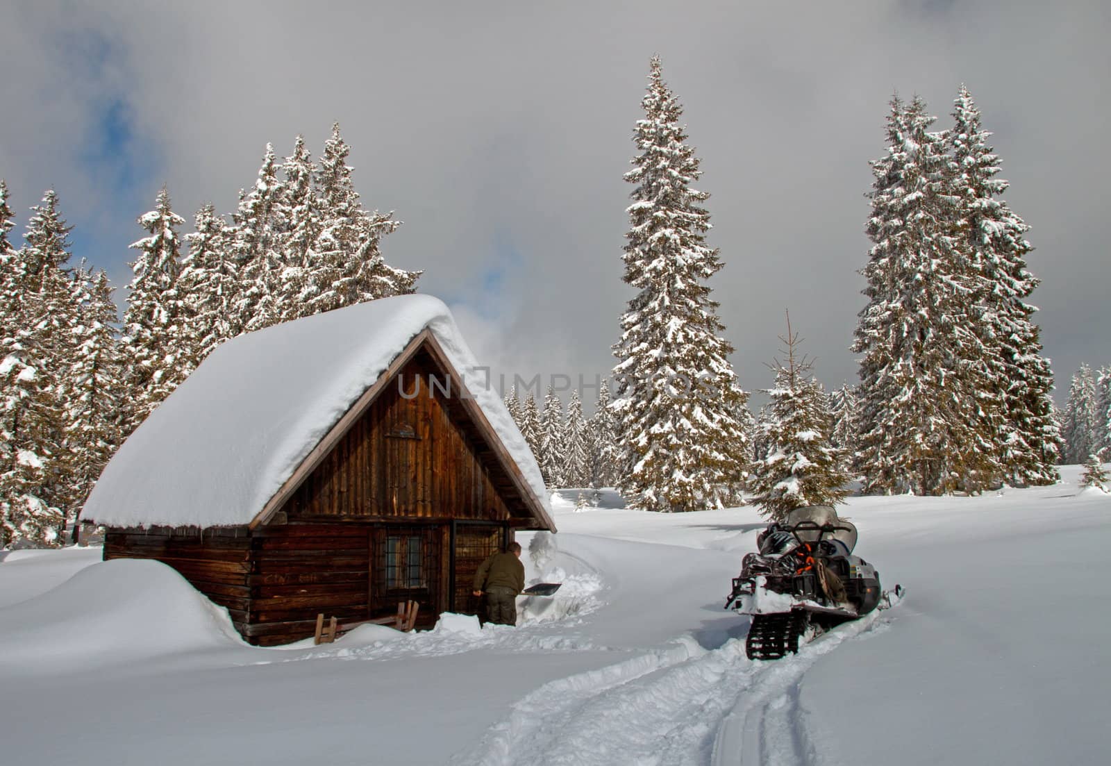 A small, wooden, snow-covered cottage in winter