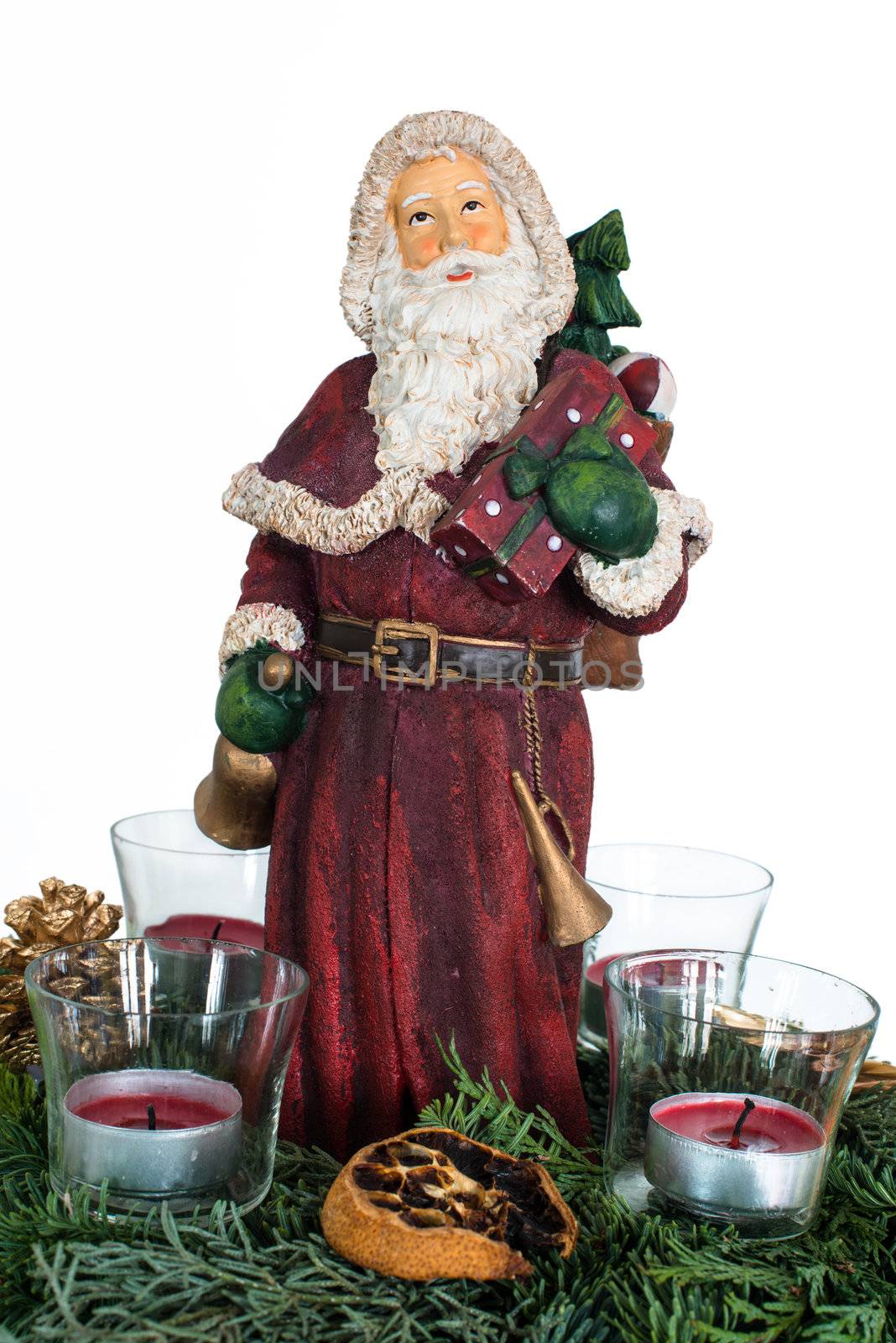 Advent wreath with burning red candles and Santa Claus figure in the centre