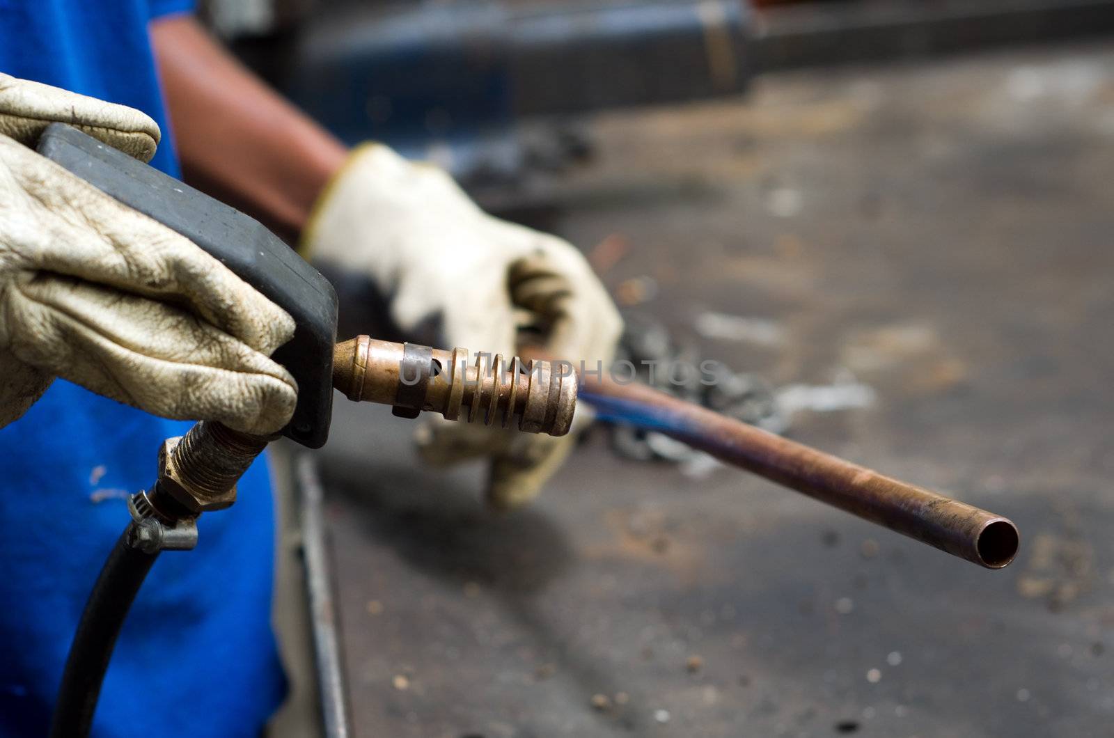 Welder worker heating copper pipe