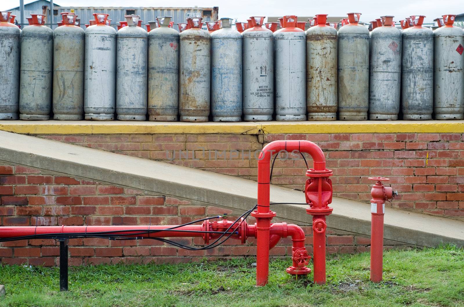 Fire hydrant water pipe in front of lpg gas bottles by alistaircotton