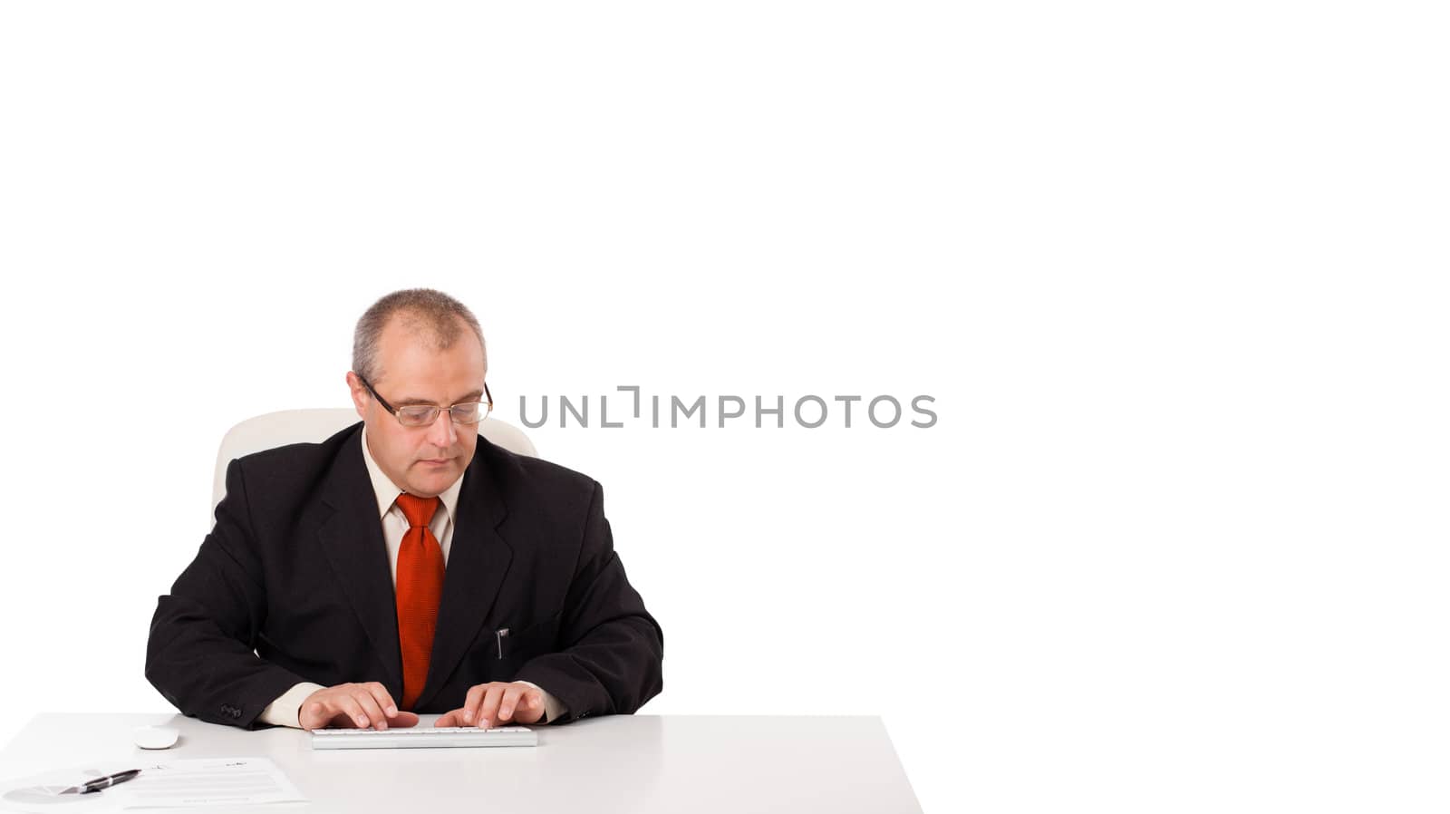 businessman sitting at desk and typing on keyboard with copy scape, isolated on white