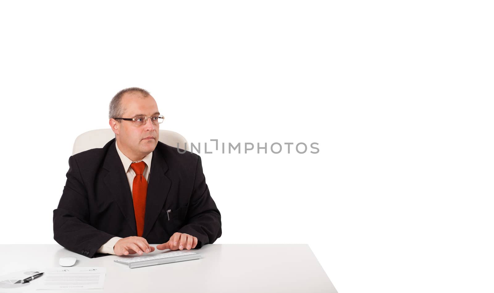 businessman sitting at desk and typing on keyboard with copy scape, isolated on white